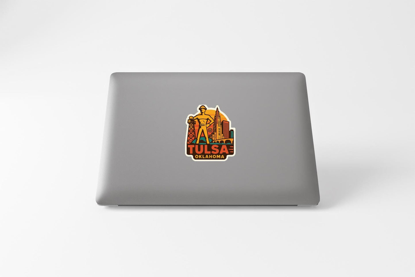 A sticker on the back of a laptop that features an illustration of a person and the text "TULSA OKLAHOMA"