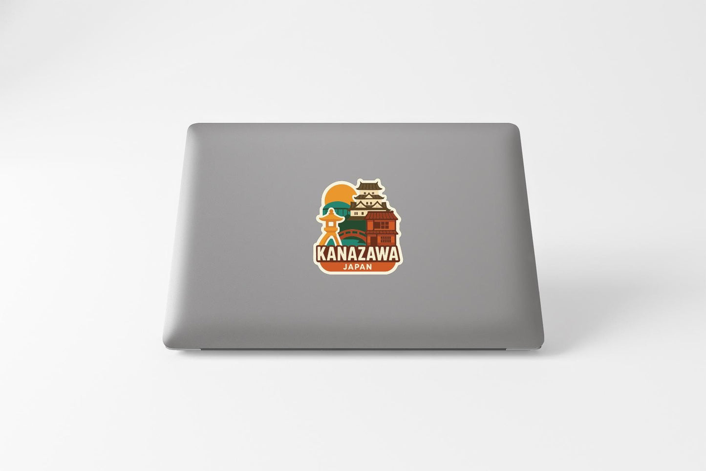 a sticker with a graphic of a building and the text "KANAZAWA JAPAN" on the back of a laptop.