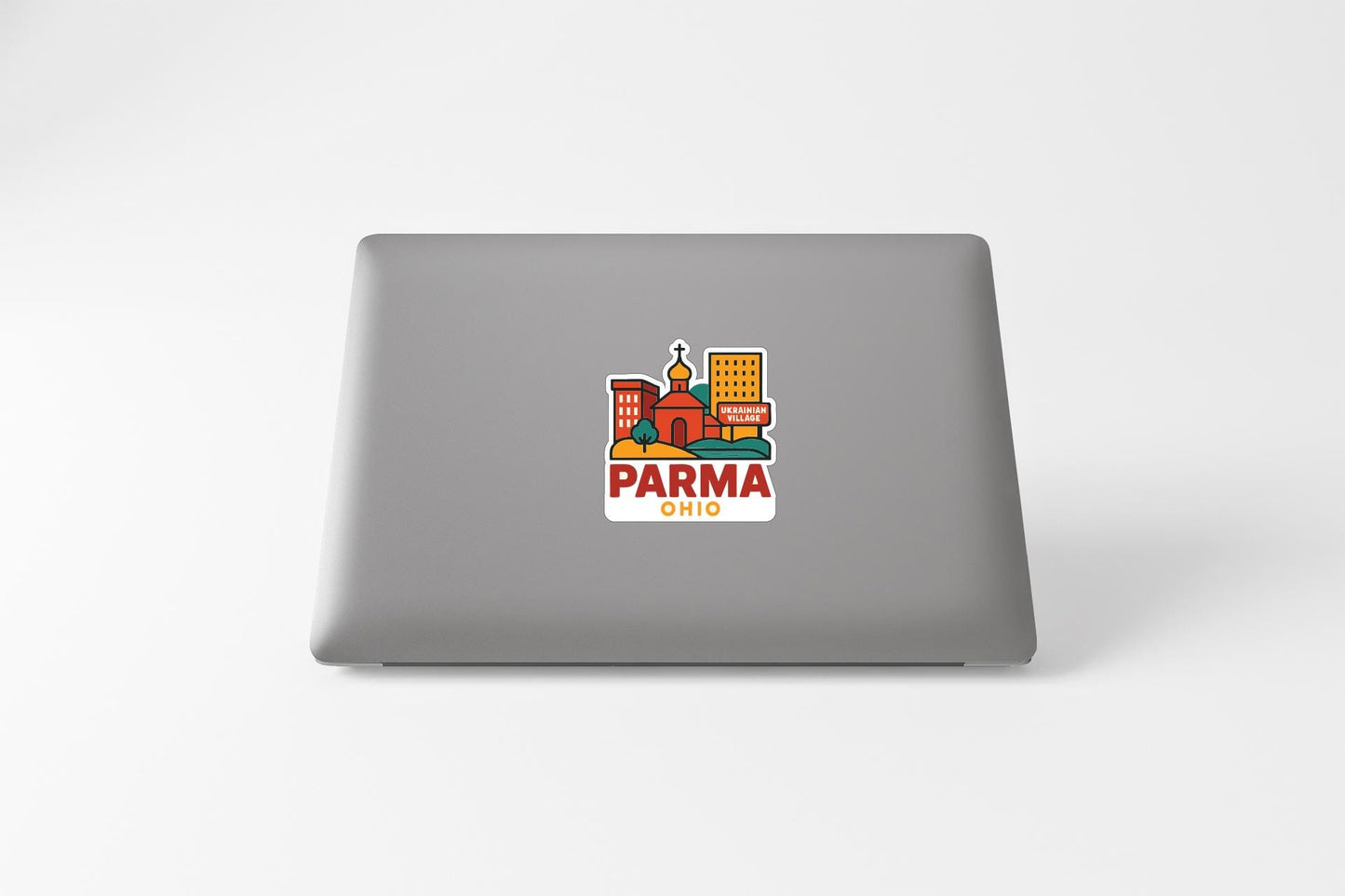 a sticker with a cityscape and the text "PARMA OHIO" on the back of a laptop.