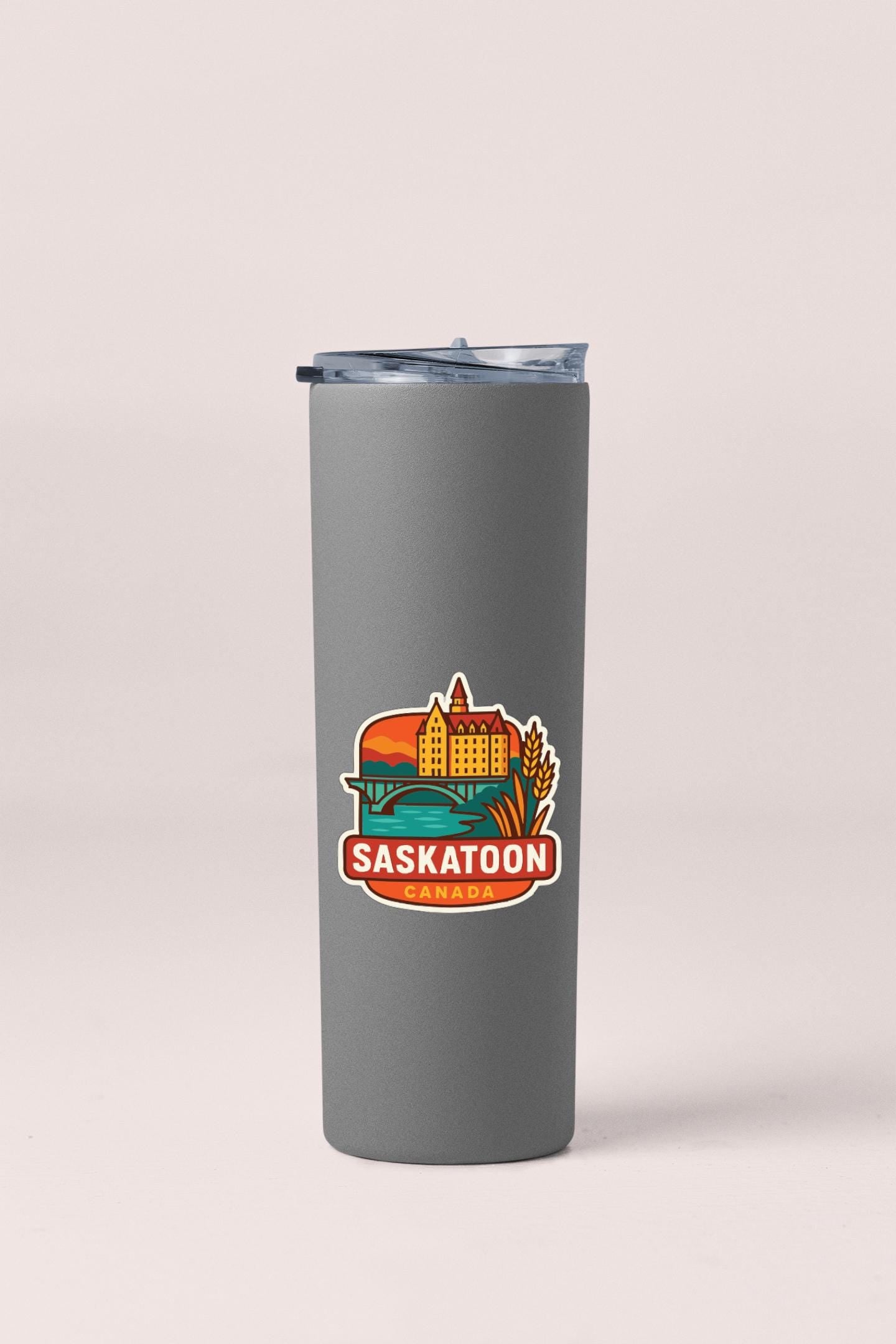 A gray insulated tumbler with a printed logo of the city of Saskatoon, Canada.