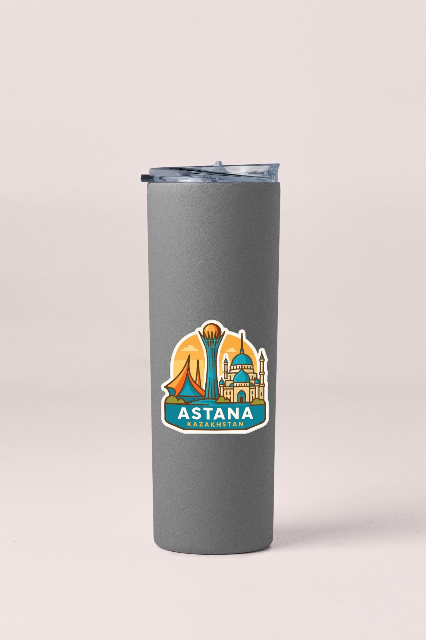 A gray insulated tumbler with a sticker depicting the skyline of Astana, the capital city of Kazakhstan.