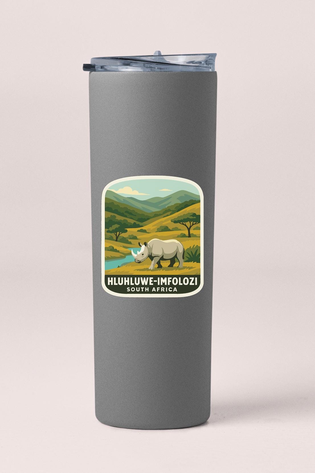 A gray tumbler with a label depicting a rhinoceros in a savanna landscape, along with the text "HLUHLWE-IMFOLZI SOUTH AFRICA".