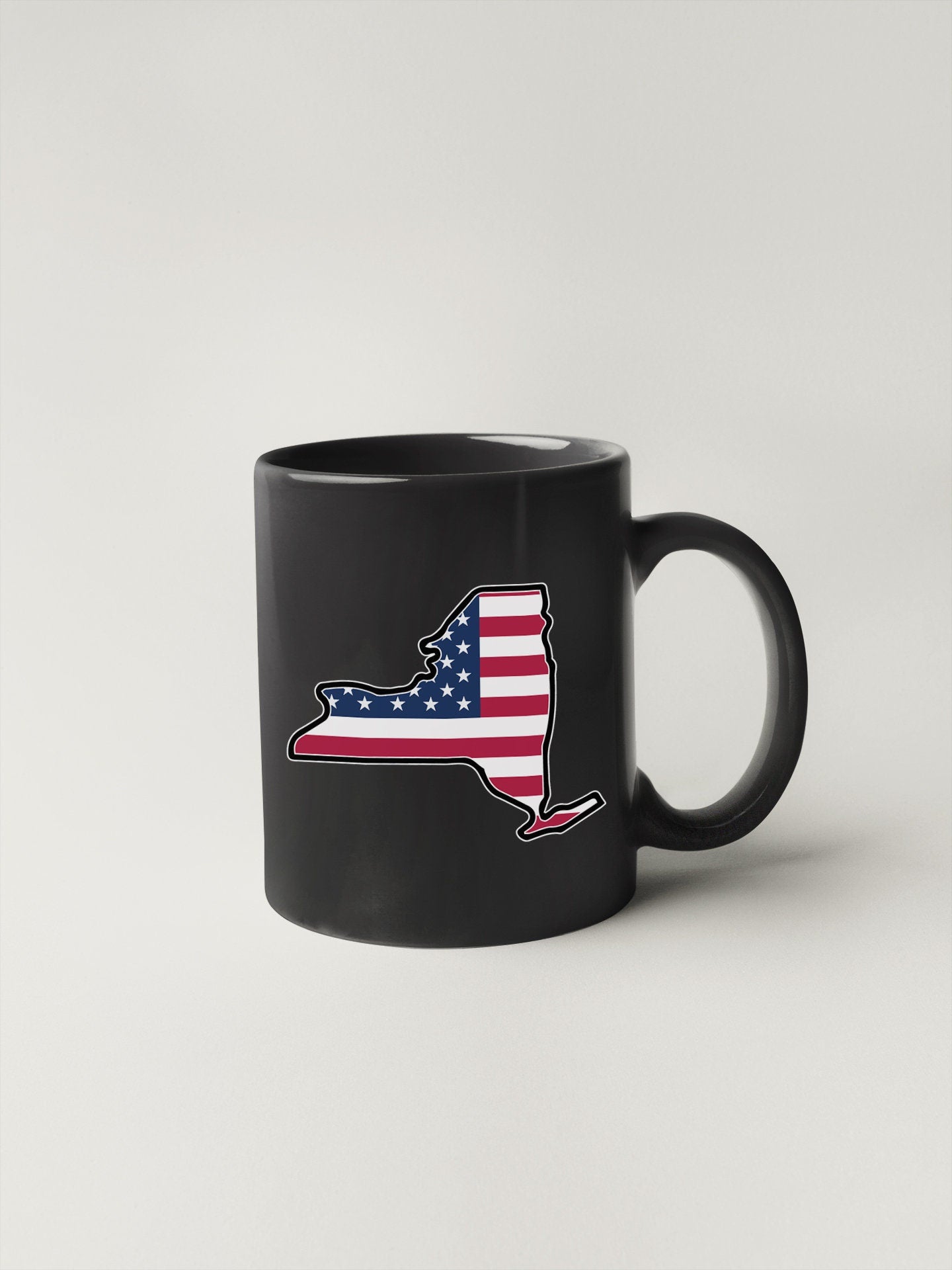 a black coffee mug with an american flag on it