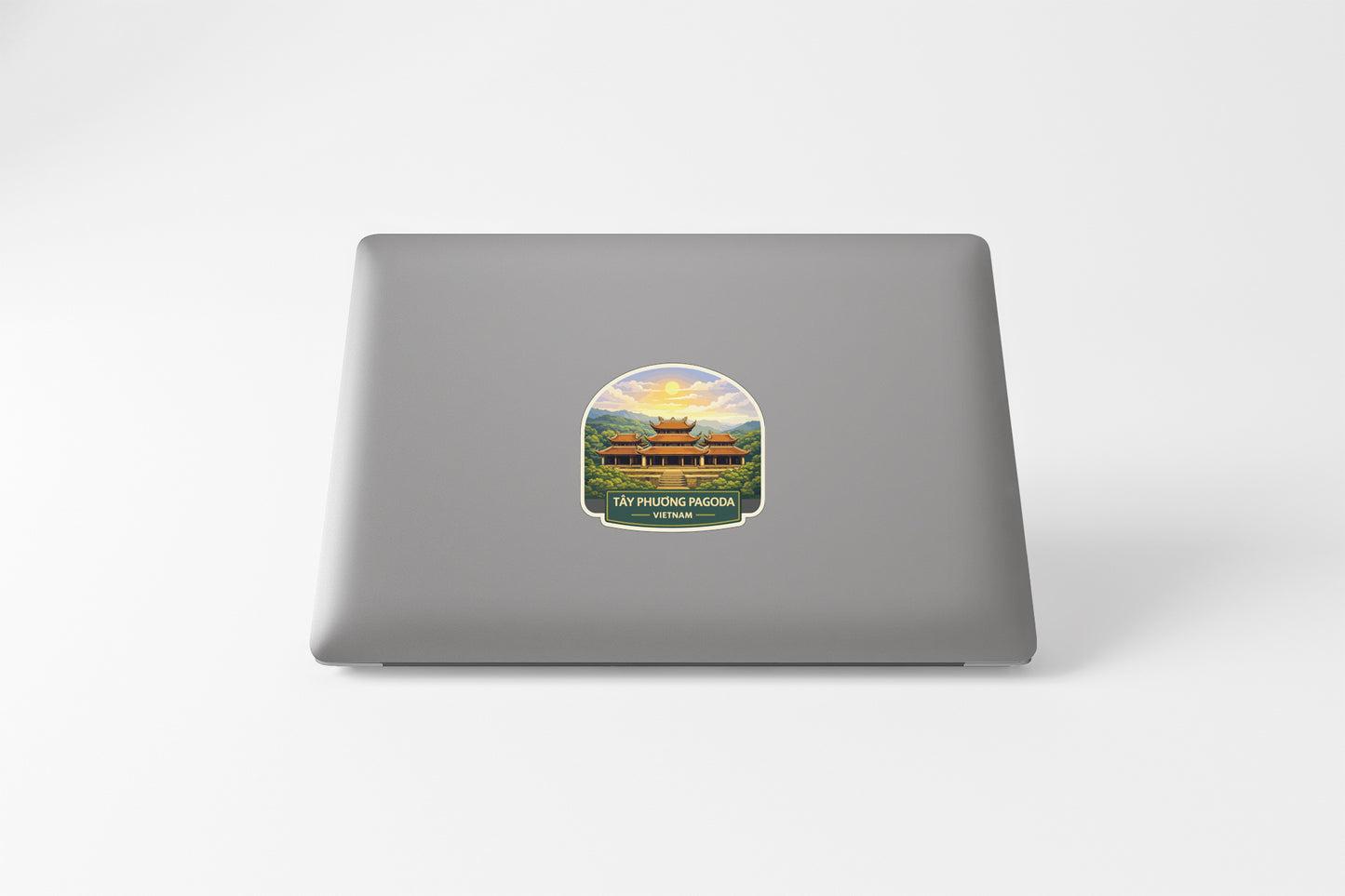 A sticker depicting a temple or pagoda on a laptop.