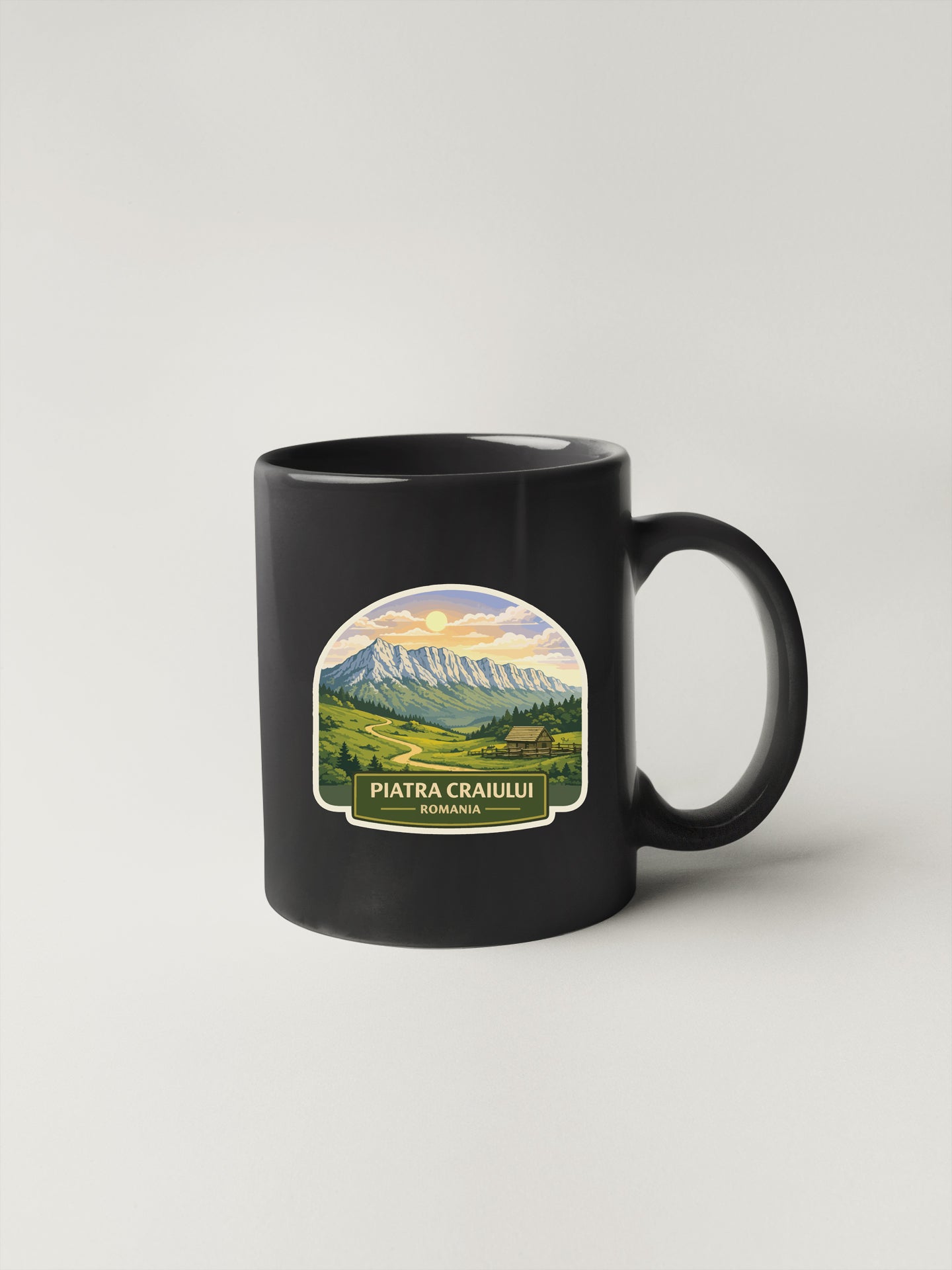 A black coffee mug with a landscape scene and mountain range printed on it.