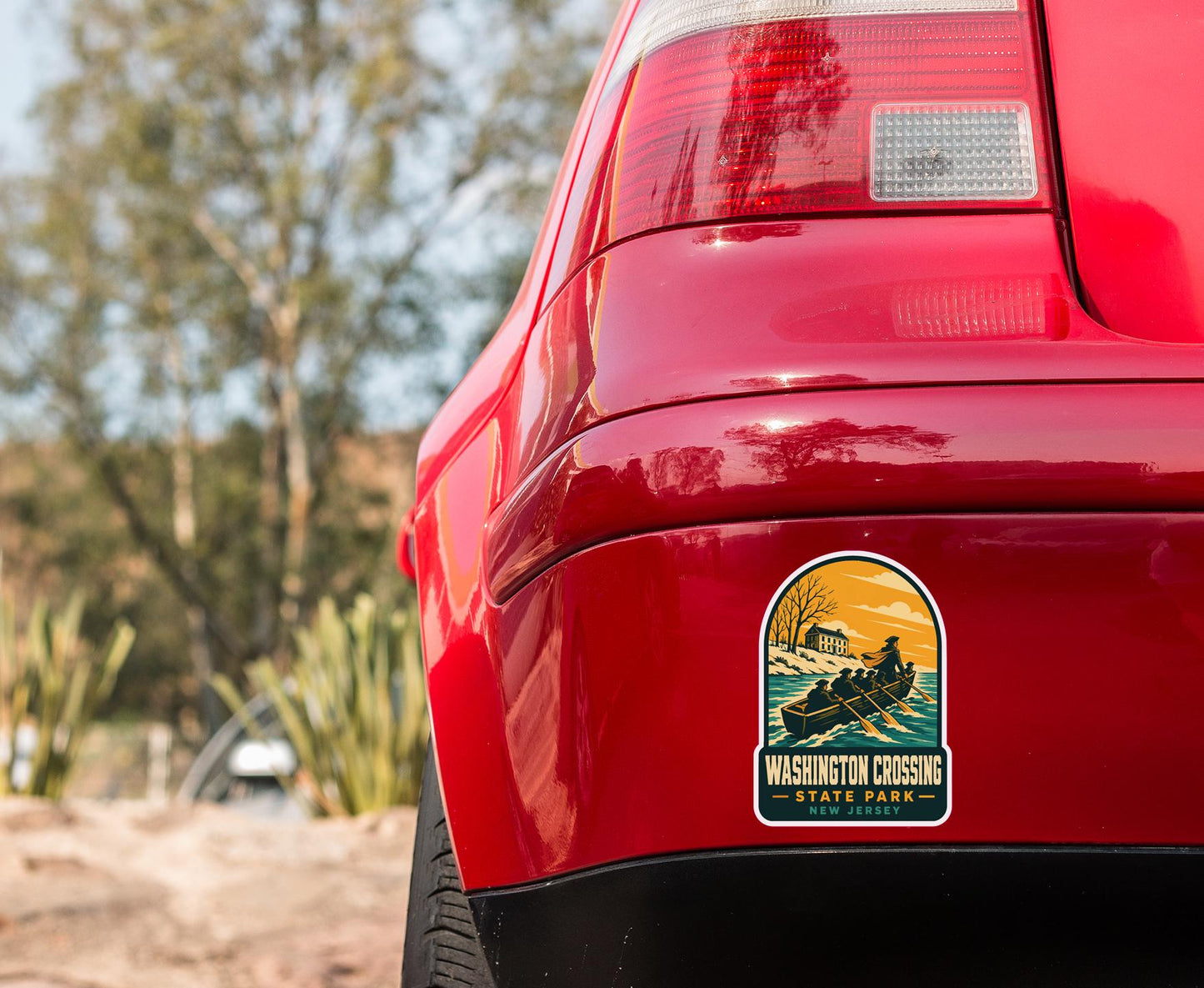 the rear end of a red car with a sticker on the bumper that says "WASHINGTON CROSSING NEW JERSEY".