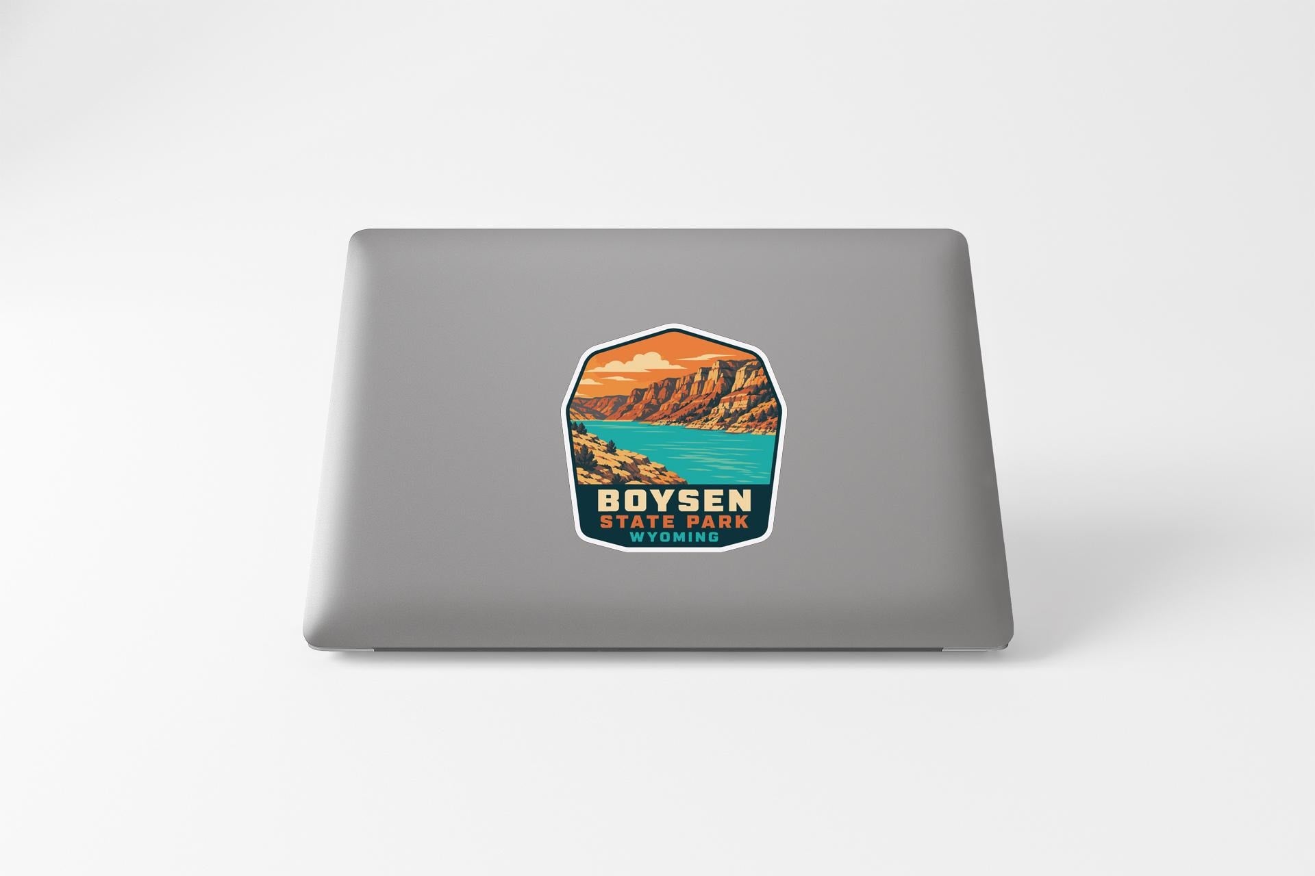 A sticker featuring a scenic landscape with mountains, a lake, and a sunset.