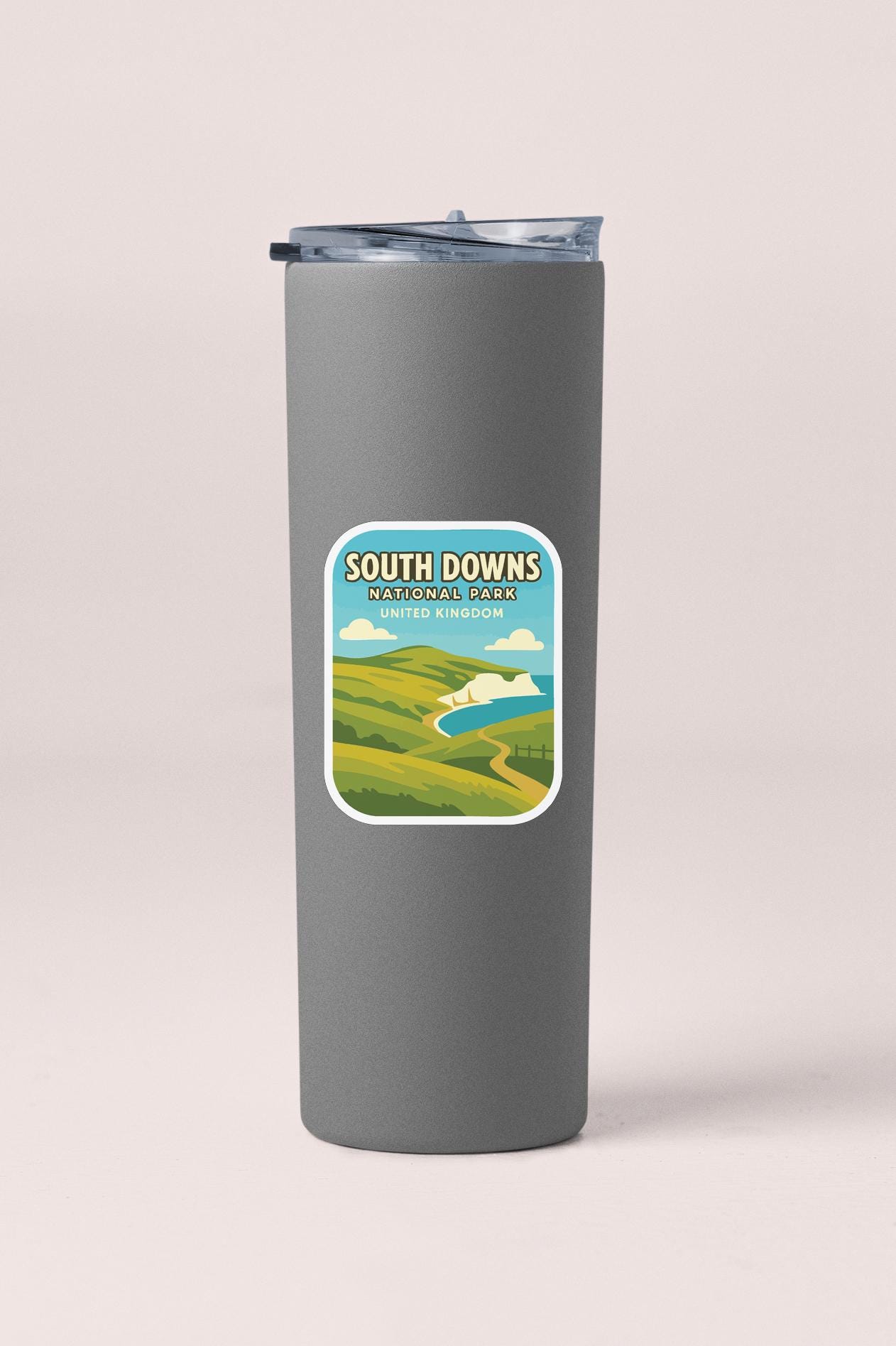 A gray insulated tumbler with a lid and a label that says "South Downs United Kingdom".