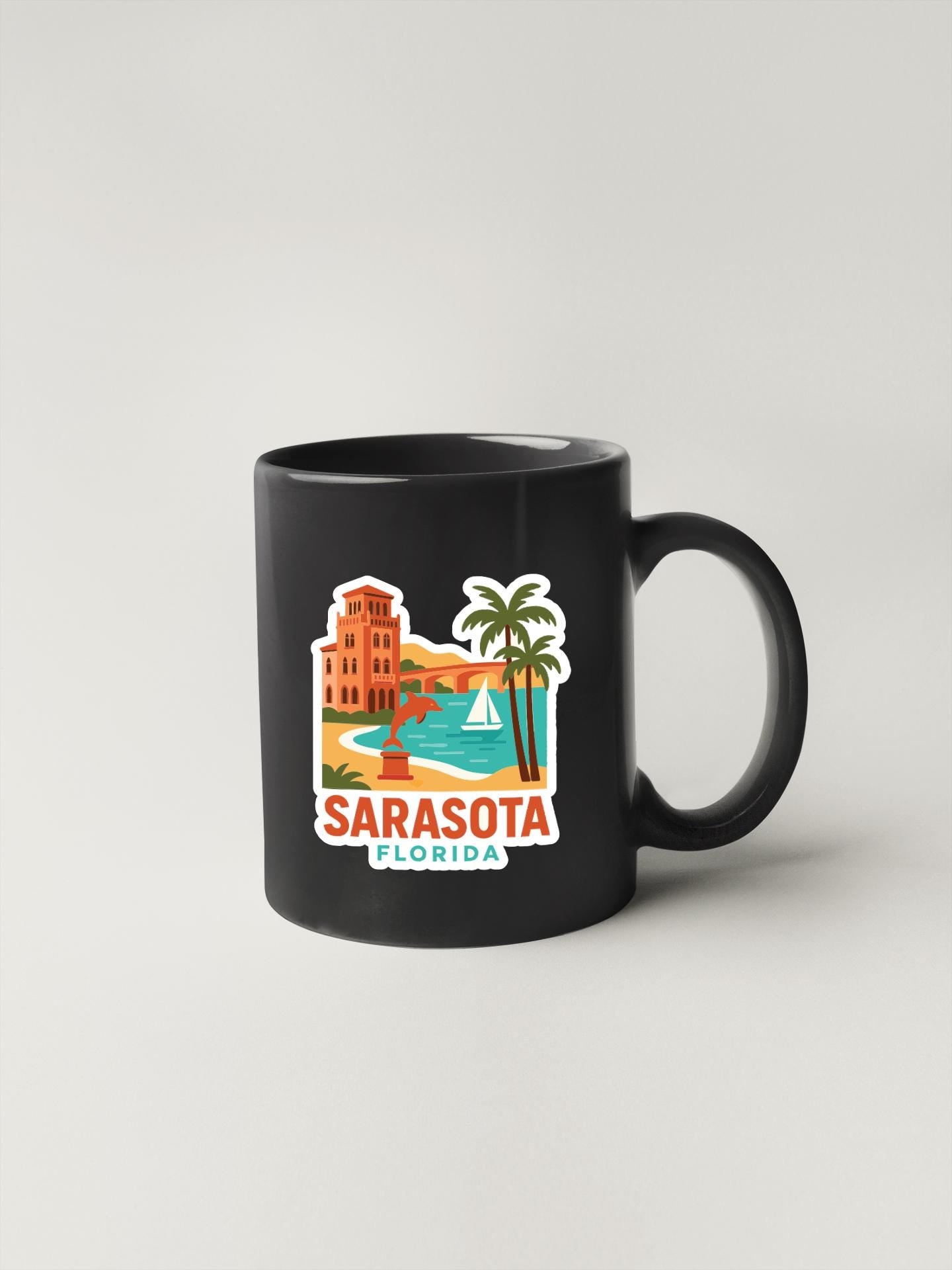 A black coffee mug with a colorful sticker depicting a beach scene and palm trees, along with the text "SARASOTA FLORIDA".
