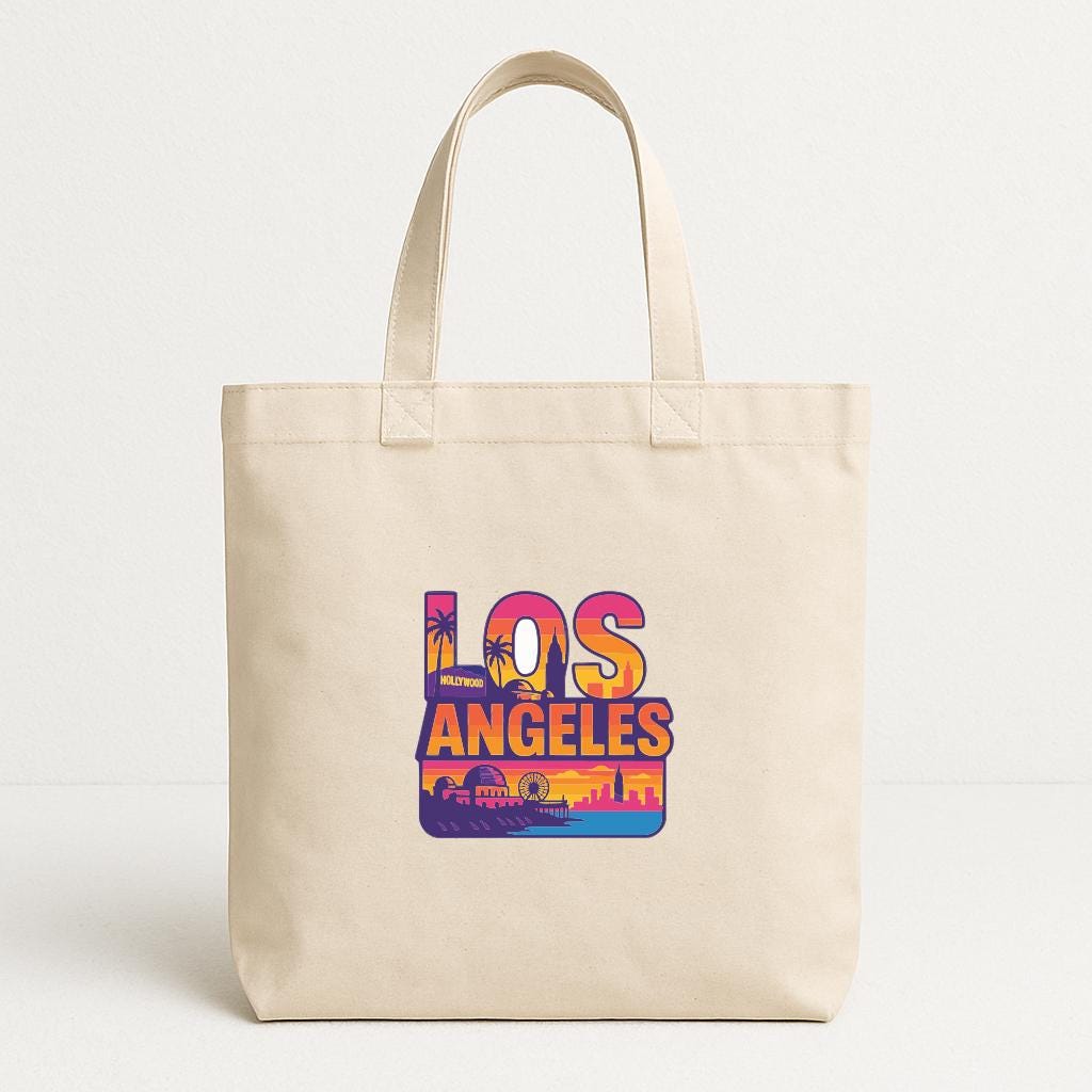 A beige tote bag with a colorful graphic of Los Angeles printed on it.