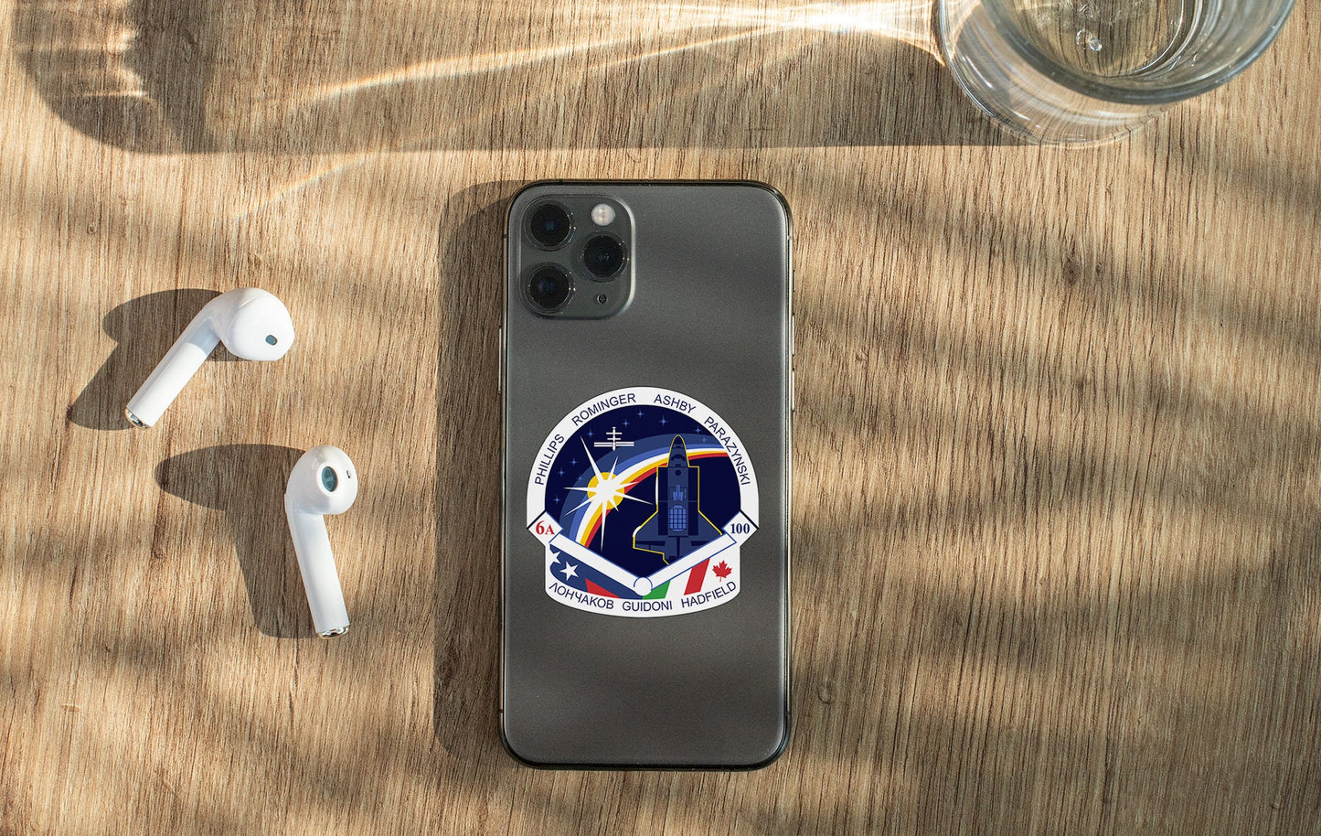 a phone with a sticker on it next to ear buds