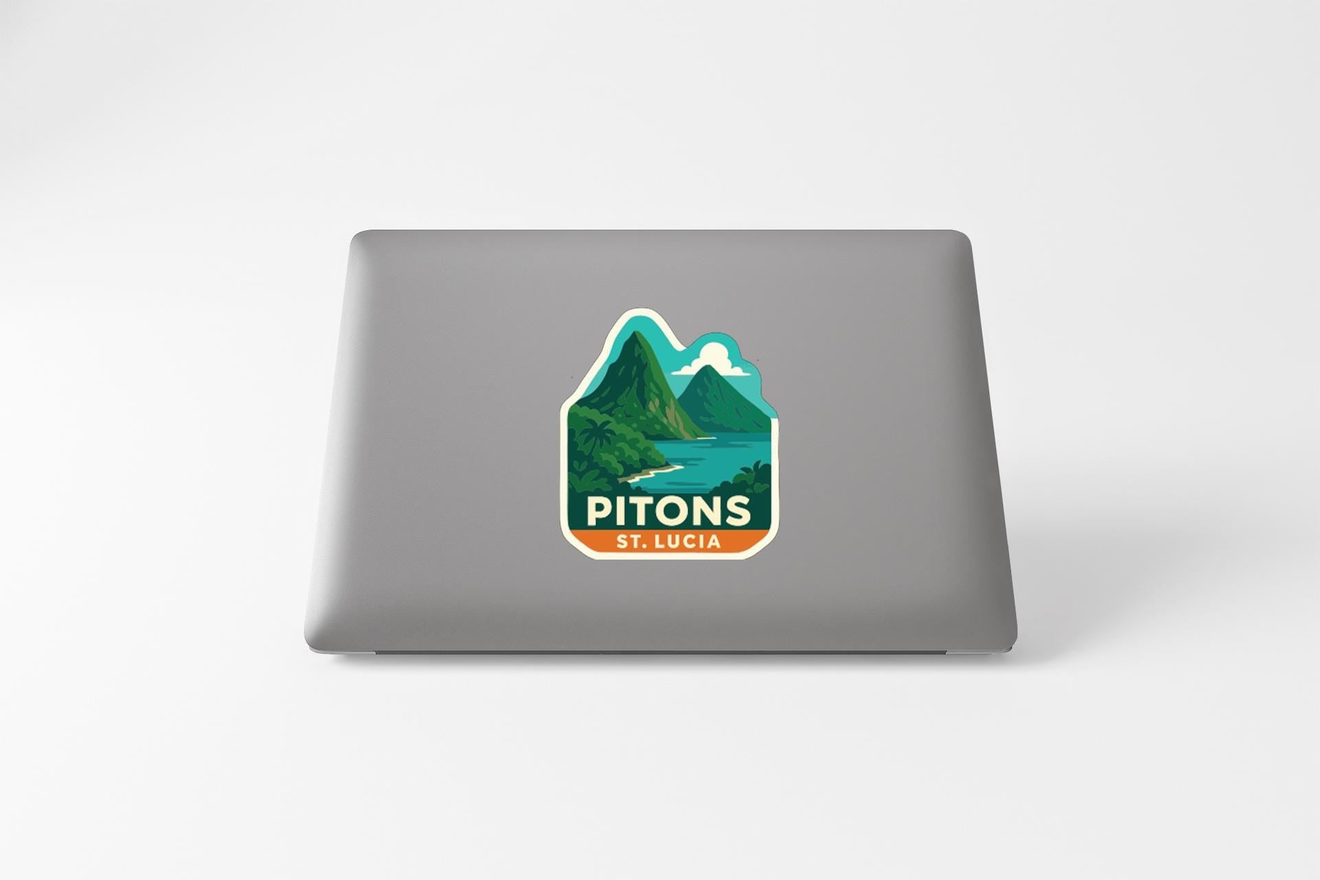 A sticker on the back of a laptop displaying a mountain landscape with the text "PITONS ST. LUCIA".