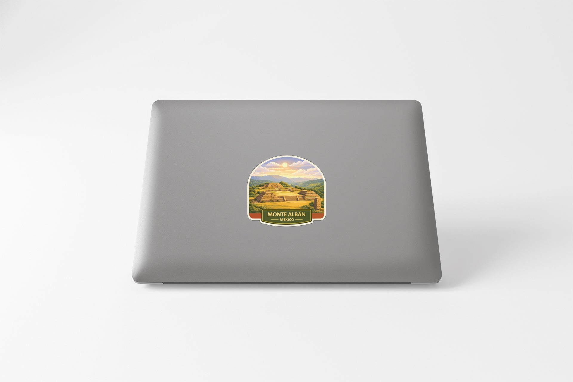 a sticker with a scenic landscape on the back of a laptop.
