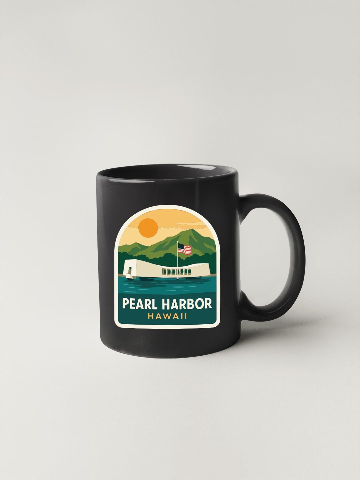 A black coffee mug with a graphic design depicting Pearl Harbor, Hawaii.