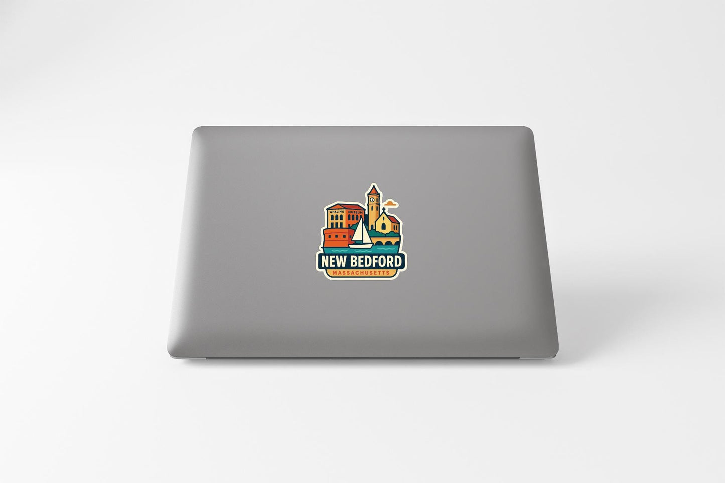 a sticker with a cityscape and the text "NEW BEDFORD" on the back of a laptop.