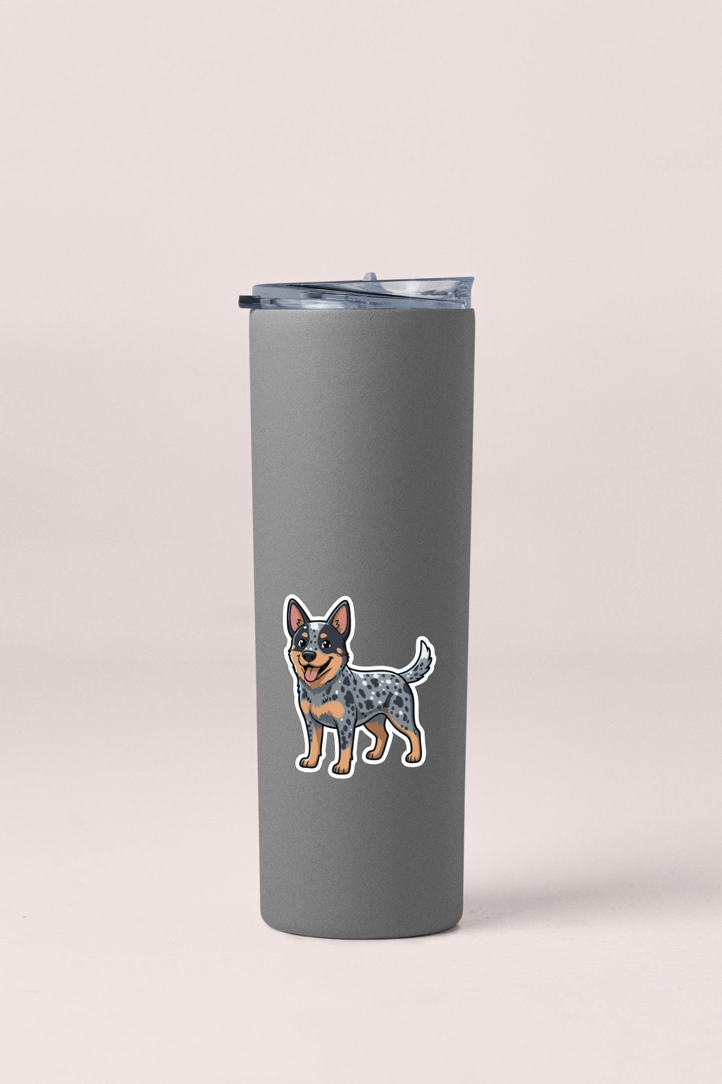 A gray insulated tumbler with a sticker of a cartoon dog on it.
