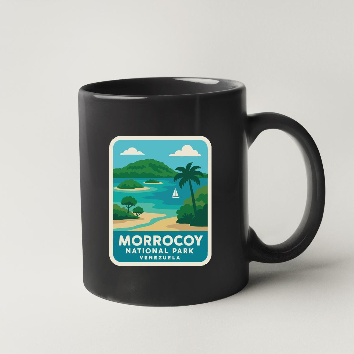 A black coffee mug with a graphic design depicting a tropical landscape, including a palm tree, a body of water, and a mountain range.
