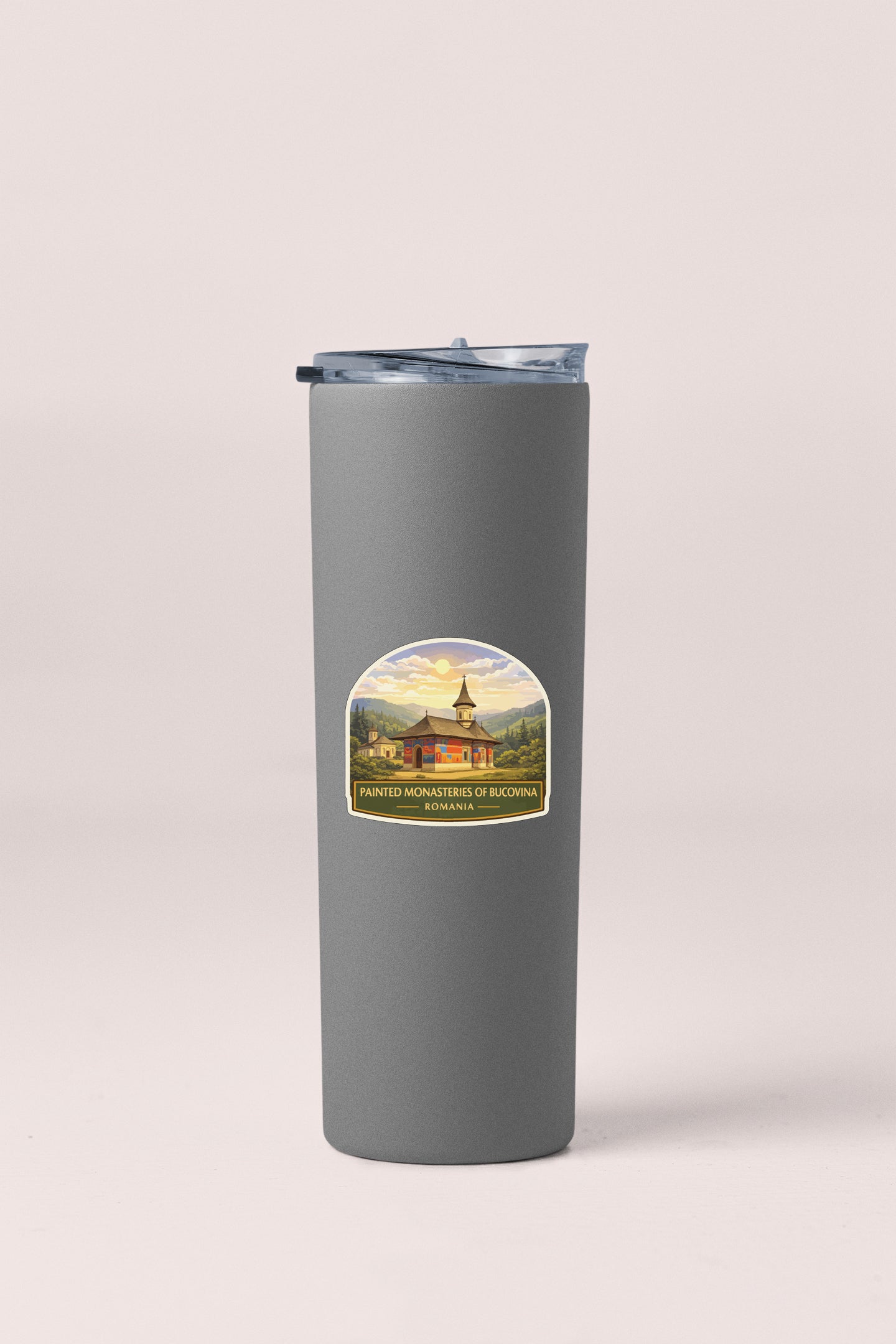 A gray insulated tumbler with a label featuring a painting of a building and the text "Painter's Monasteries of Bucovina Romania".
