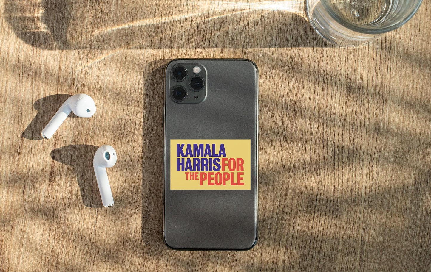 a cell phone with a sticker on it next to ear buds