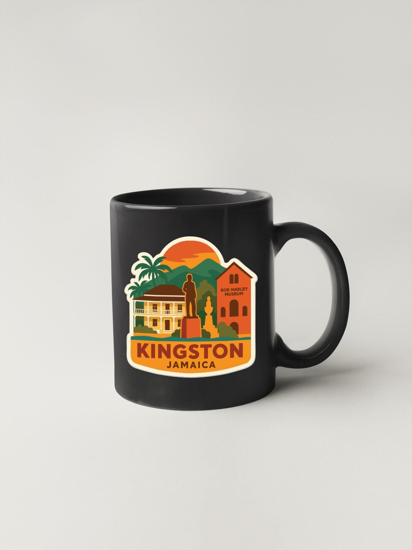 A black coffee mug with a colorful illustration of landmarks and buildings in Kingston, Jamaica.