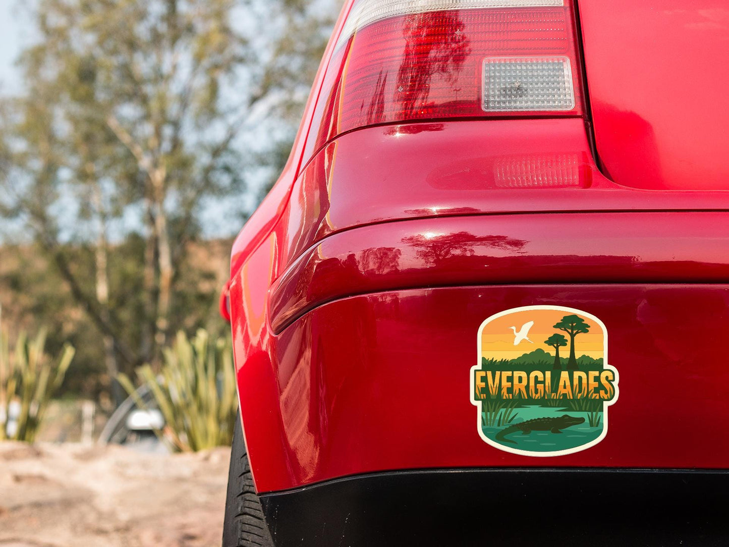 the rear end of a red car with a sticker on the trunk that says "EVERGLADES".