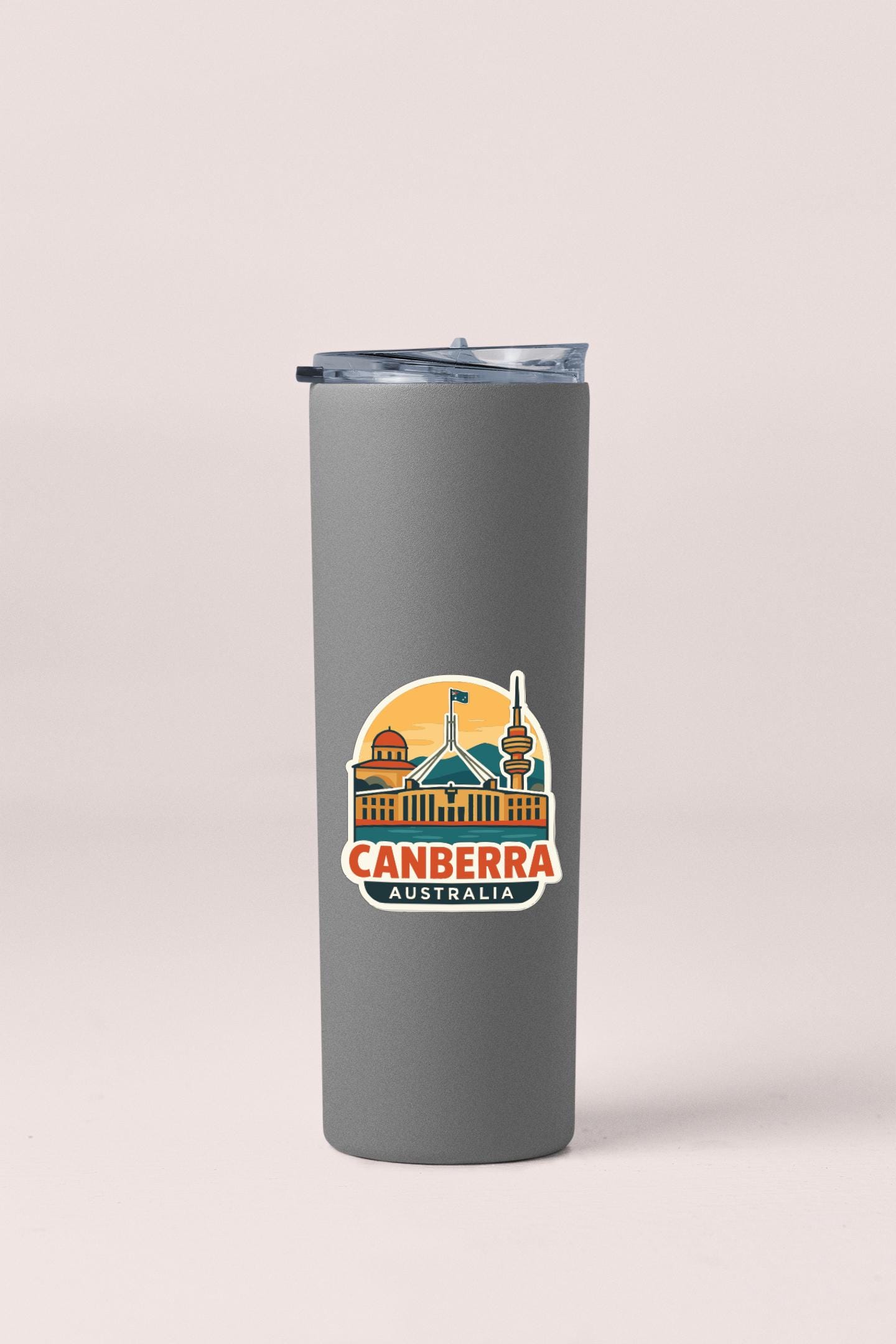 A gray tumbler with a sticker depicting the skyline of the city of Canberra, Australia.