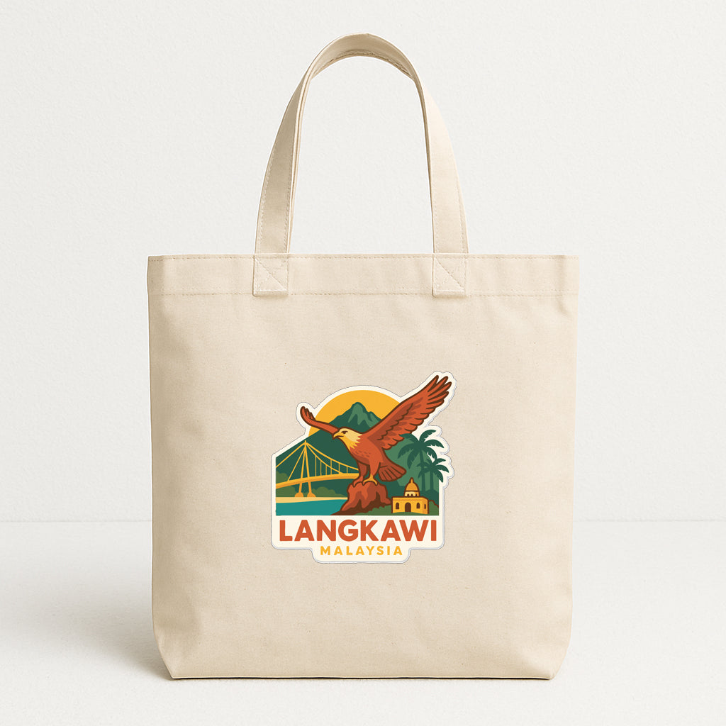 A beige tote bag with a printed design depicting a bird, a bridge, and mountains, along with the text "LANGKAWI MALAYSIA".