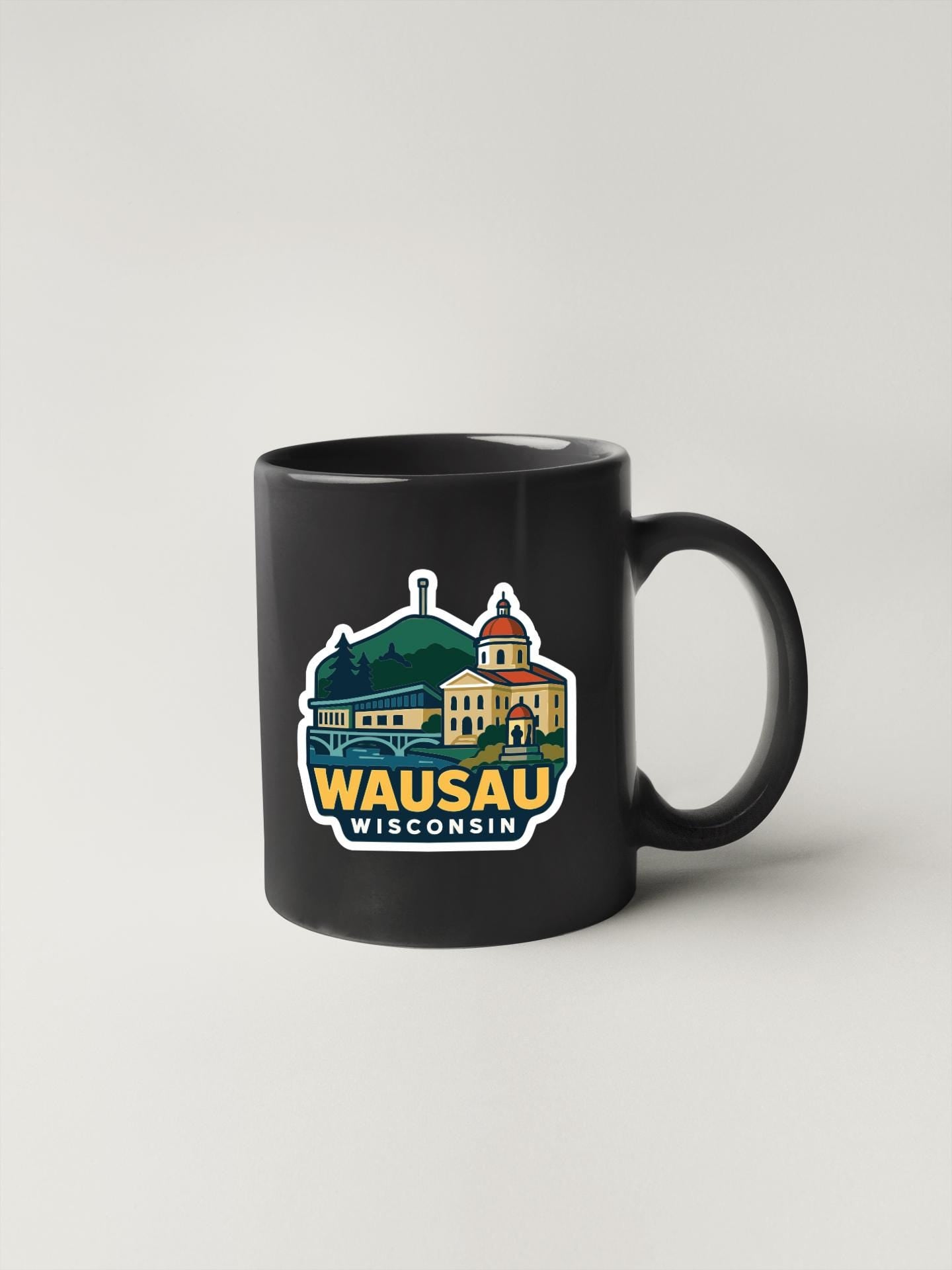 A black coffee mug with a colorful graphic depicting a landmark in Wisconsin.