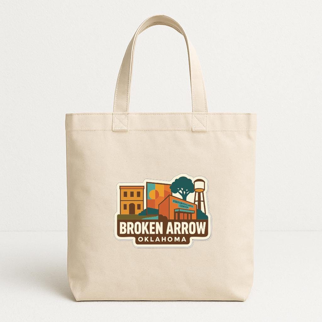 A beige tote bag with a printed logo that says "Broken Arrow Oklahoma".