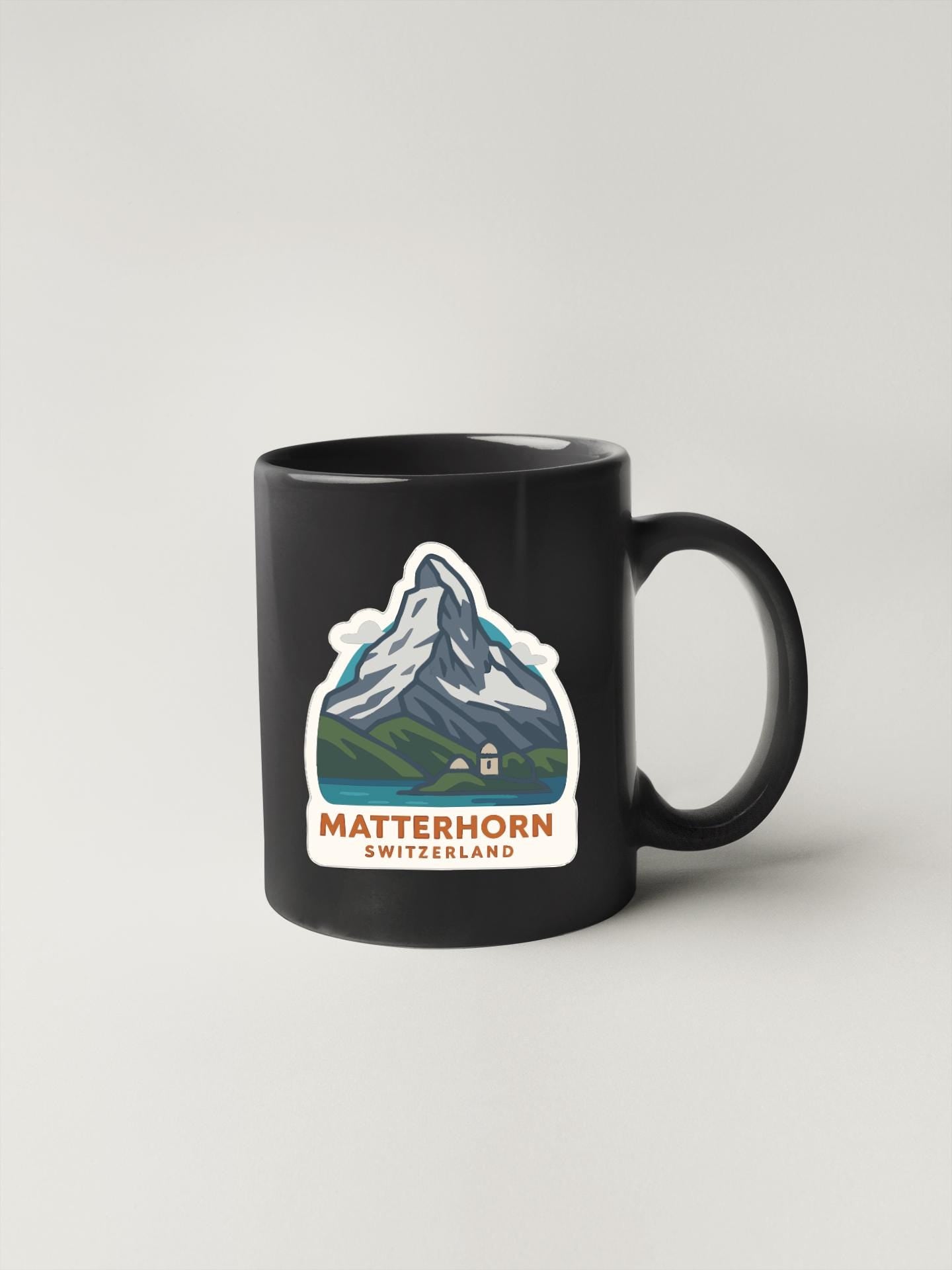 A black coffee mug with a mountain landscape and the text "MATTERHORN SWITZERLAND" printed on it.