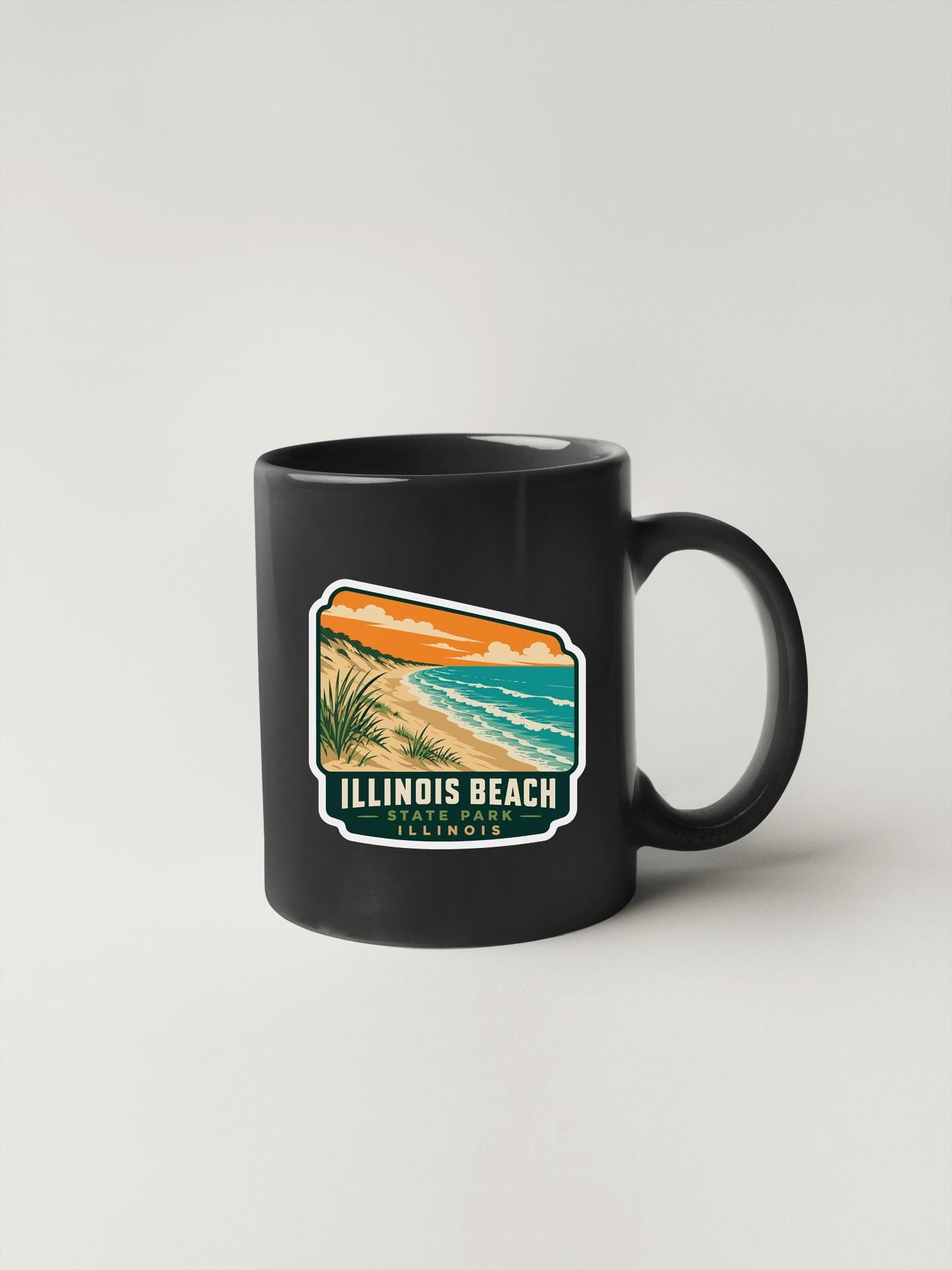 A black coffee mug with a graphic design depicting a beach scene, featuring a palm tree, ocean waves, and a sunset.