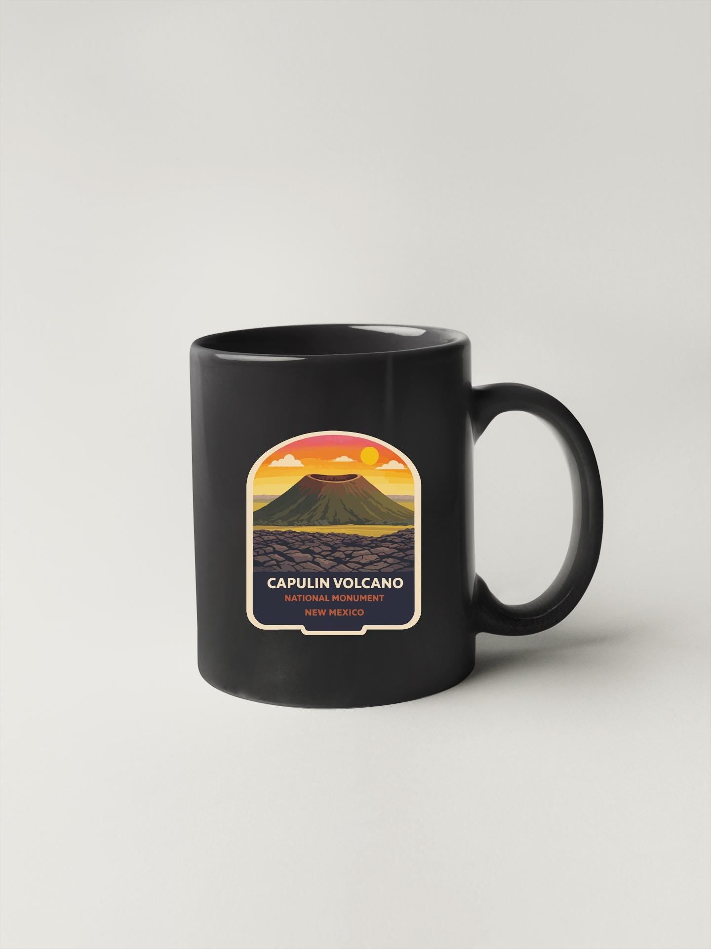 A black coffee mug with a label that says "CAPULIN VOLCANO" and "NATIONAL HONOR".