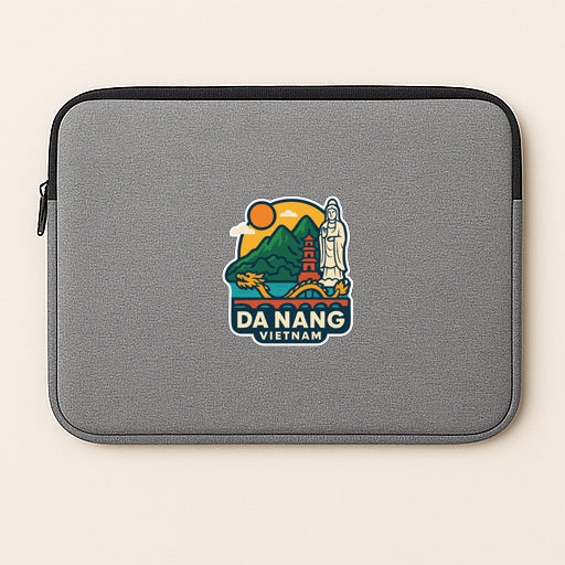 A gray laptop sleeve with a colorful sticker depicting a scenic view of Da Nang, Vietnam.