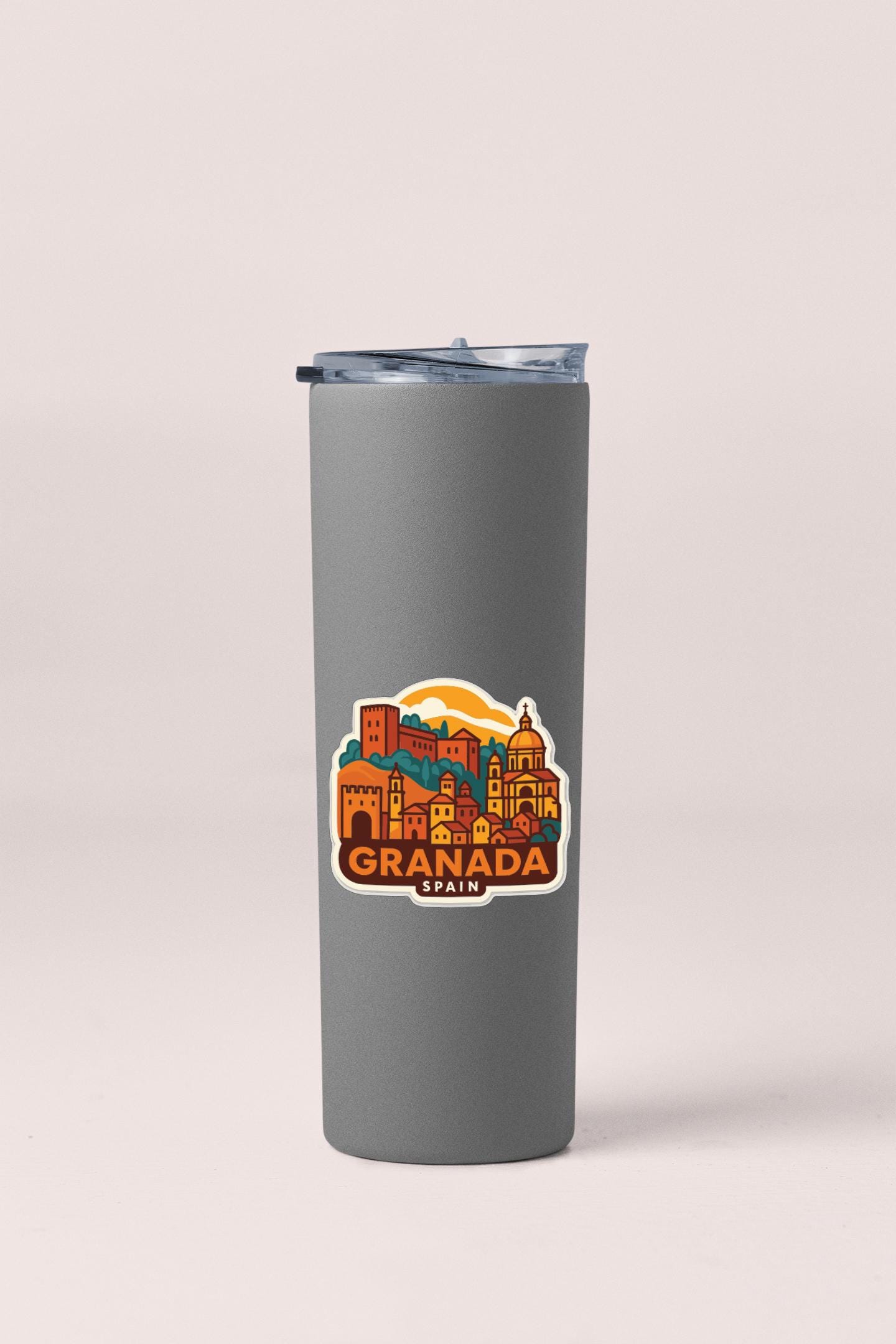A gray insulated tumbler with a colorful sticker depicting the city of Granada, Spain.