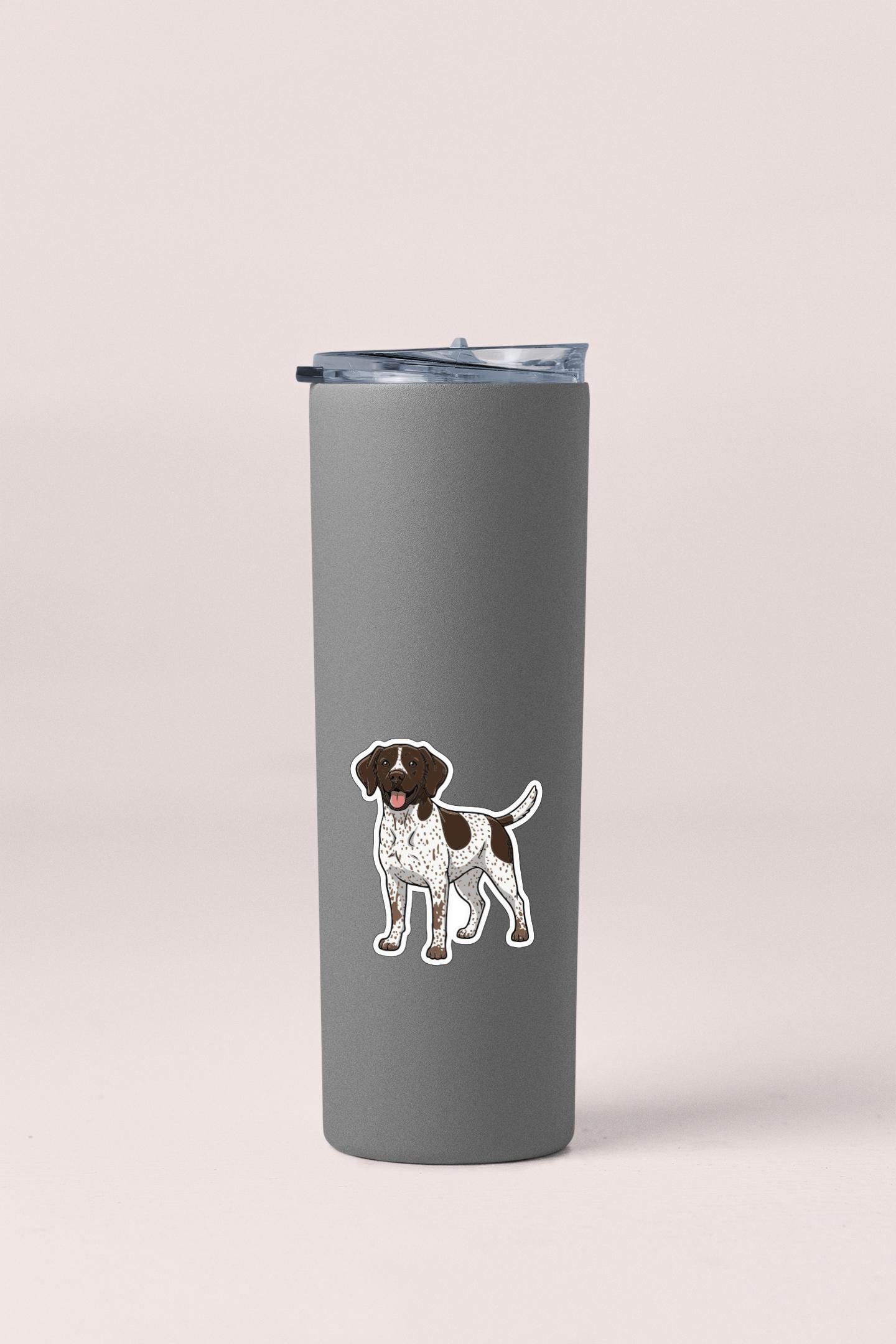 A gray insulated tumbler with a sticker of a dog on it.
