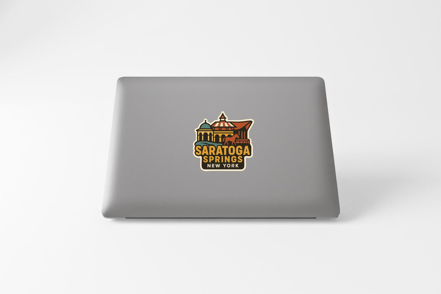 a sticker with the text "Saratoga Springs, New York" on a grey laptop.