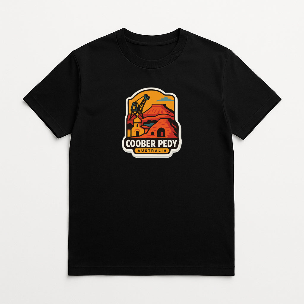A black t-shirt with a colorful graphic design depicting a building and a crane, along with the text "COOBER PEDY AUSTRALIA".
