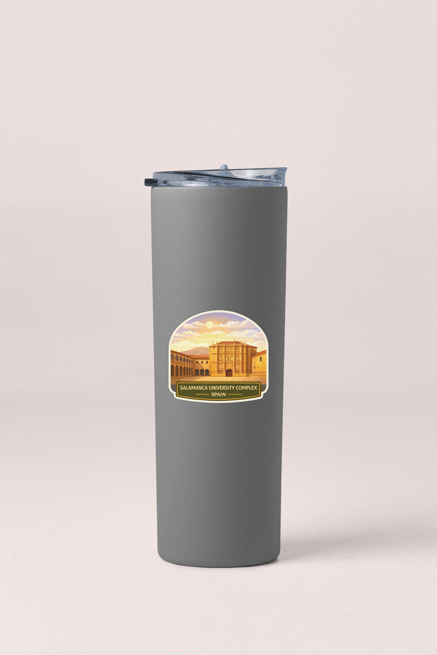 A gray insulated tumbler with a sticker depicting a building and a sunset.