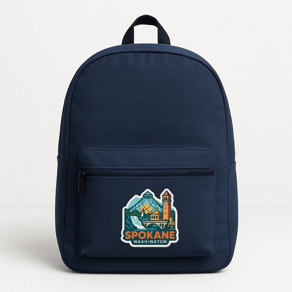 A navy blue backpack with a graphic of Spokane, Washington on the front pocket.