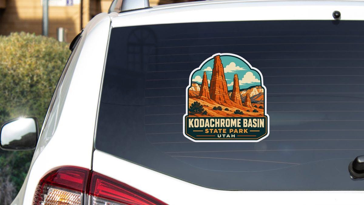 A sticker on the rear window of a white car, depicting the iconic Kodachrome Basin in Utah State Park.