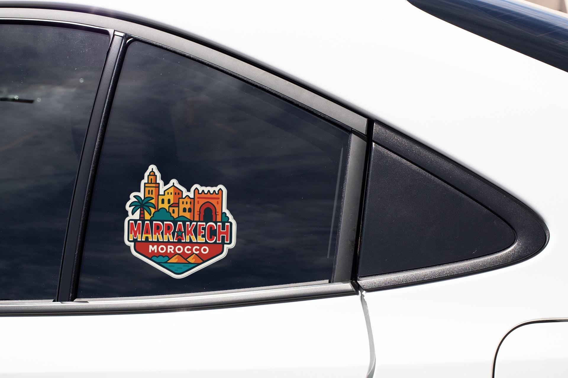 A sticker on the side of a car window, featuring the text "MARAKECH MOROCCO" along with a colorful illustration of a cityscape.