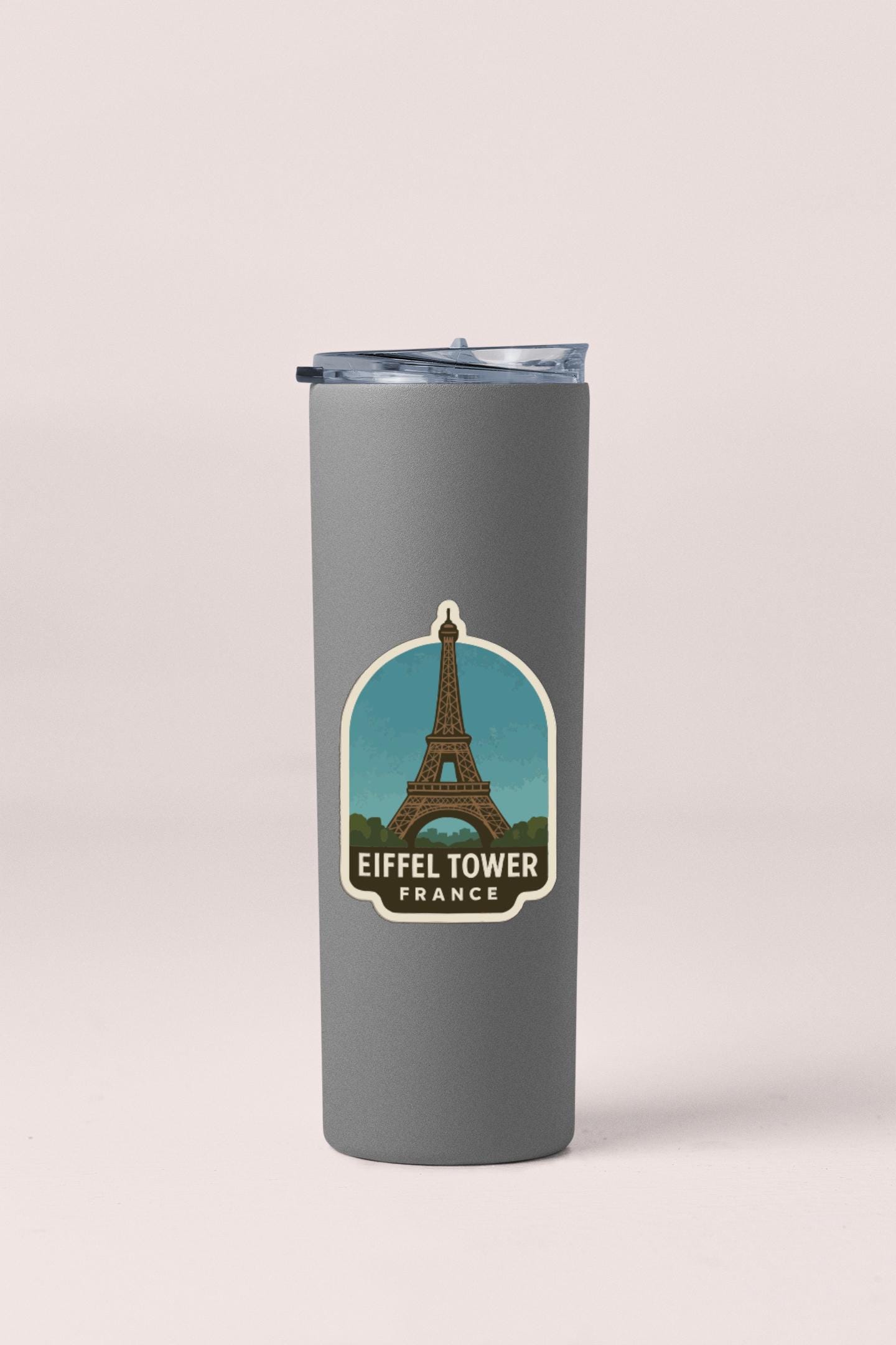A gray insulated tumbler with a sticker featuring the Eiffel Tower in France.