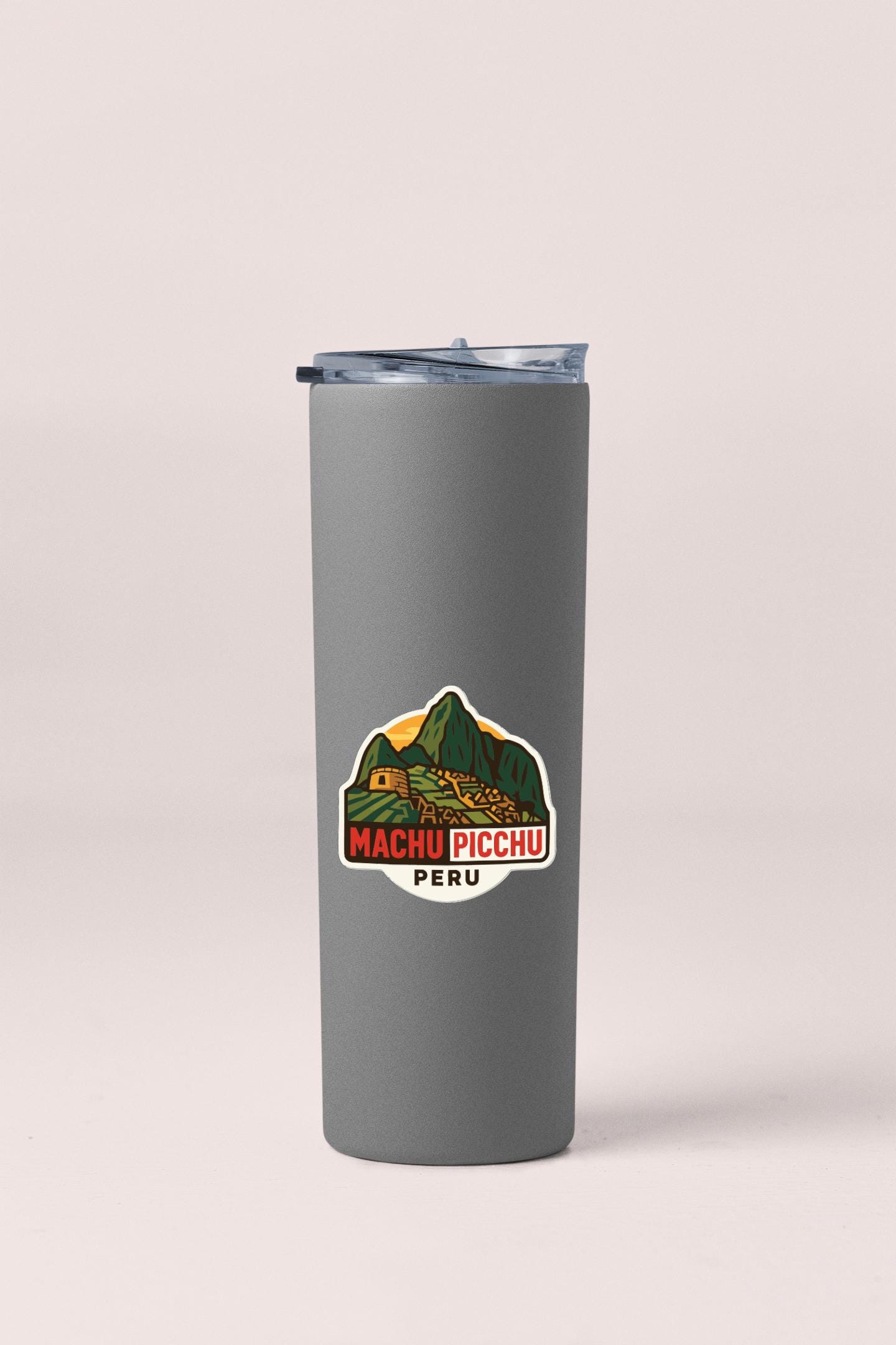 A gray insulated tumbler with a sticker depicting Machu Picchu, the ancient Inca citadel, in Peru.