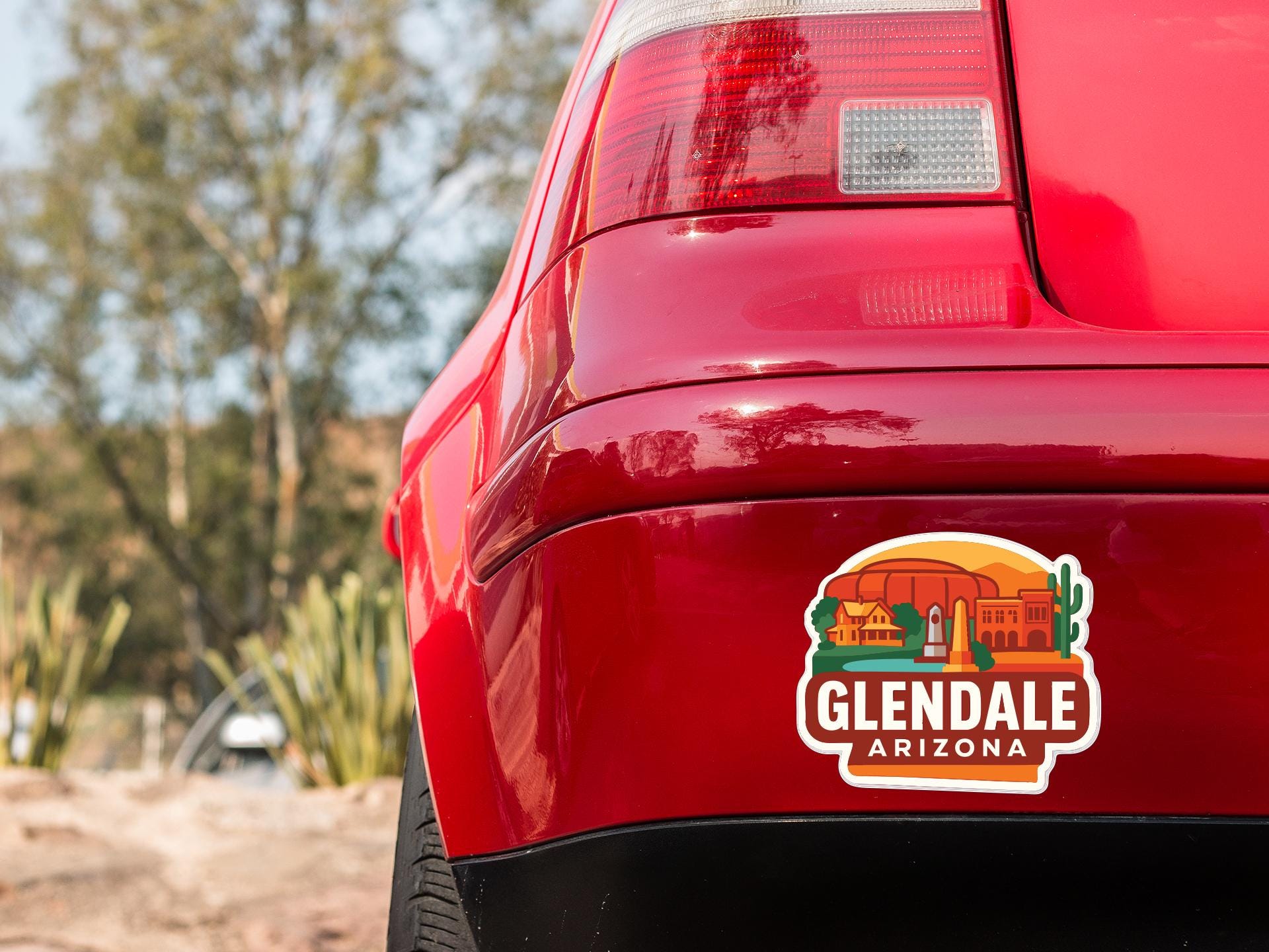 the rear end of a red car with a sticker on the back window that says "Glendale, Arizona".