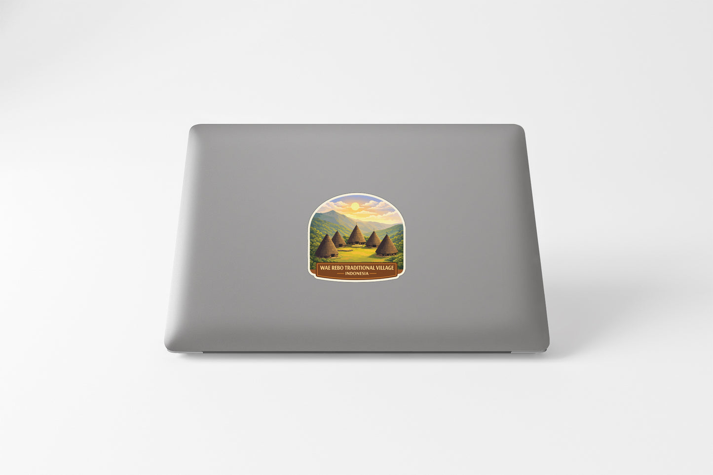 a sticker on the back of a laptop, depicting a scenic landscape with mountains and a lake.
