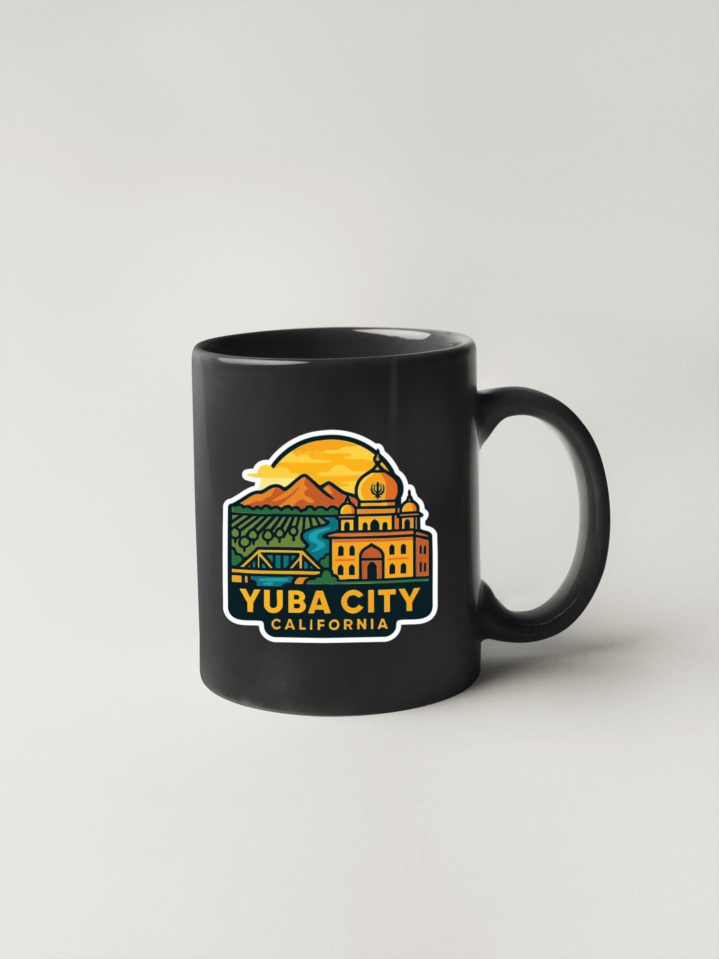 A black coffee mug with a colorful graphic depicting a cityscape and the text "YUBA CITY, CALIFORNIA".