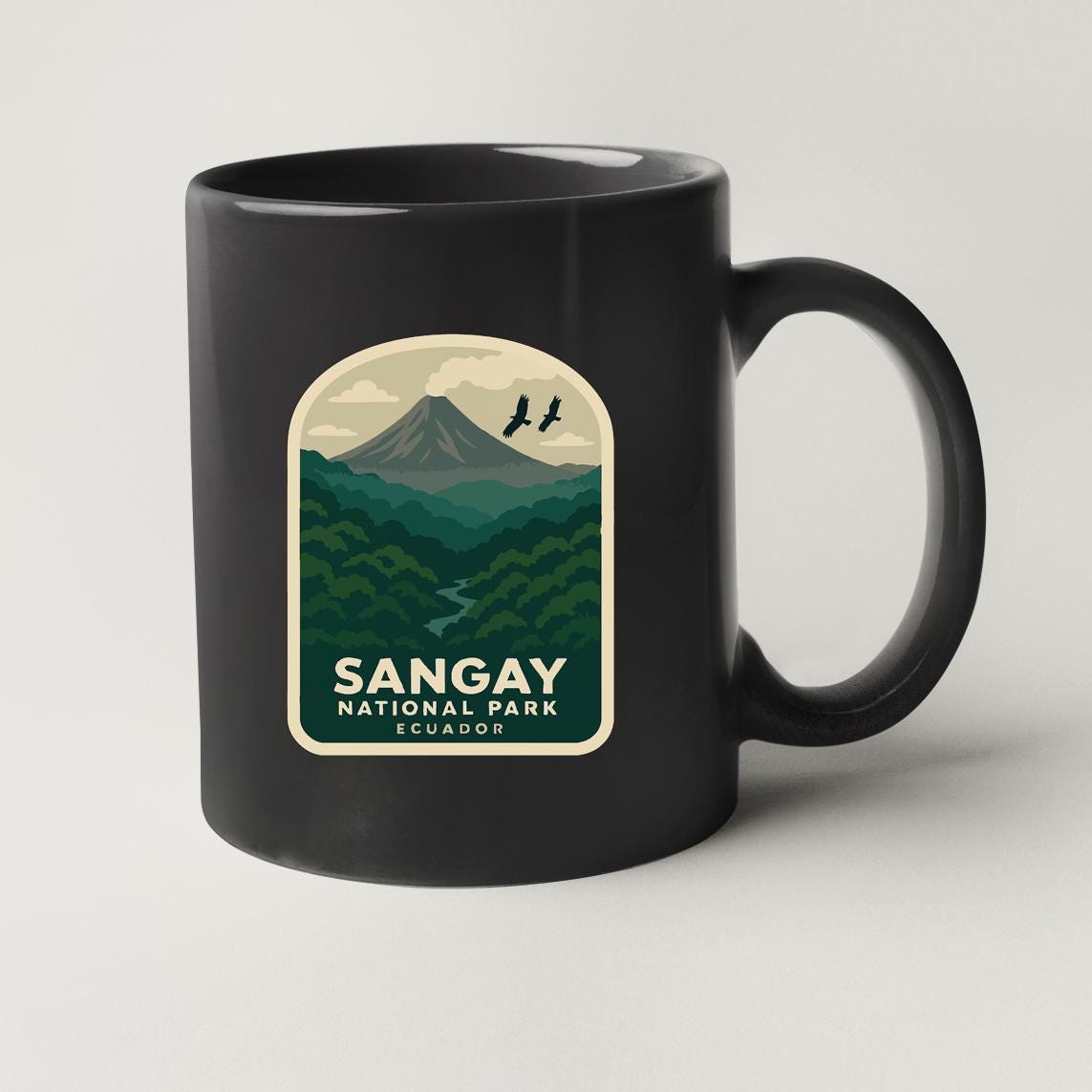 A black coffee mug with a label that features a mountain landscape and birds flying over it, along with the text "Sangay National Park Ecuador".