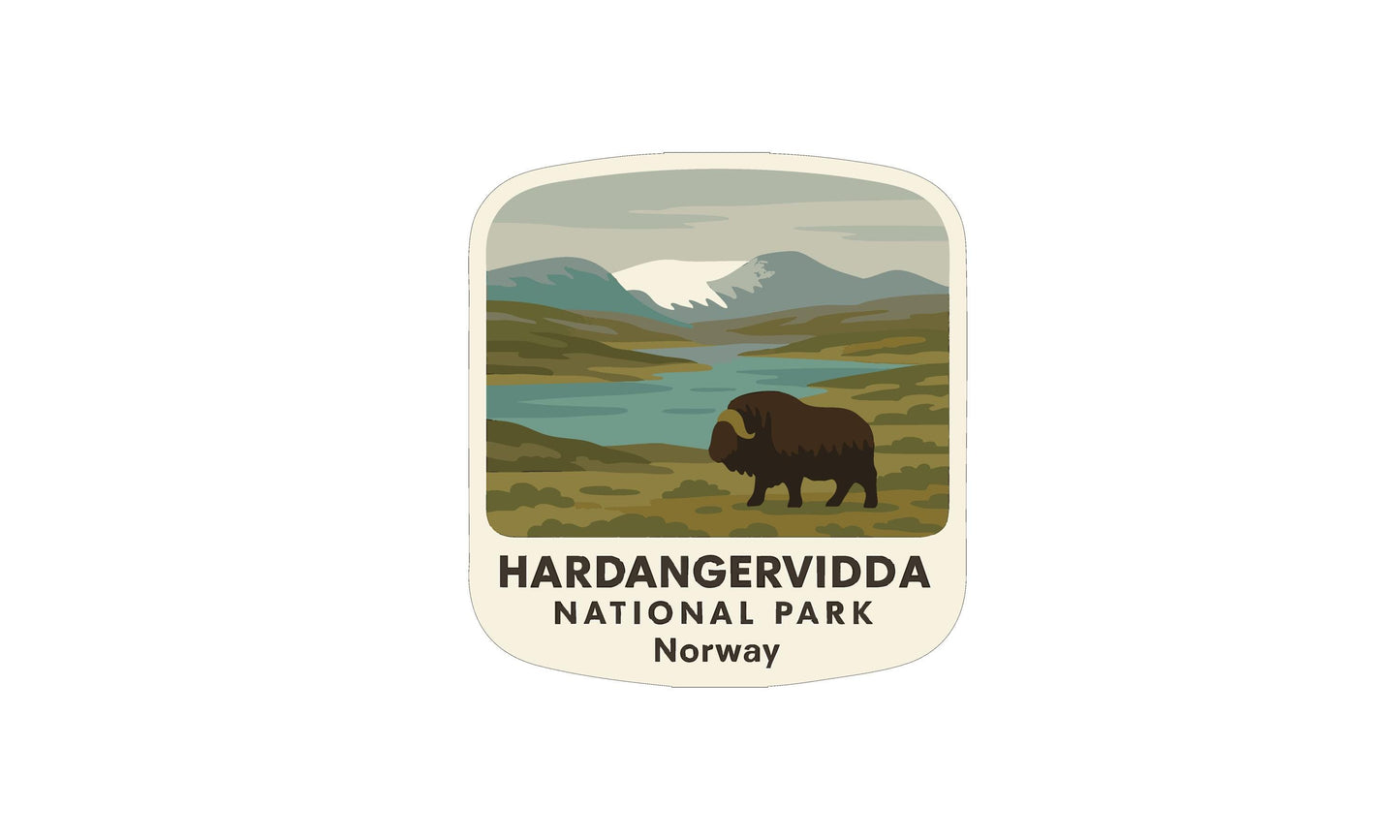 a large, brown bison standing in a grassy field with mountains in the background.