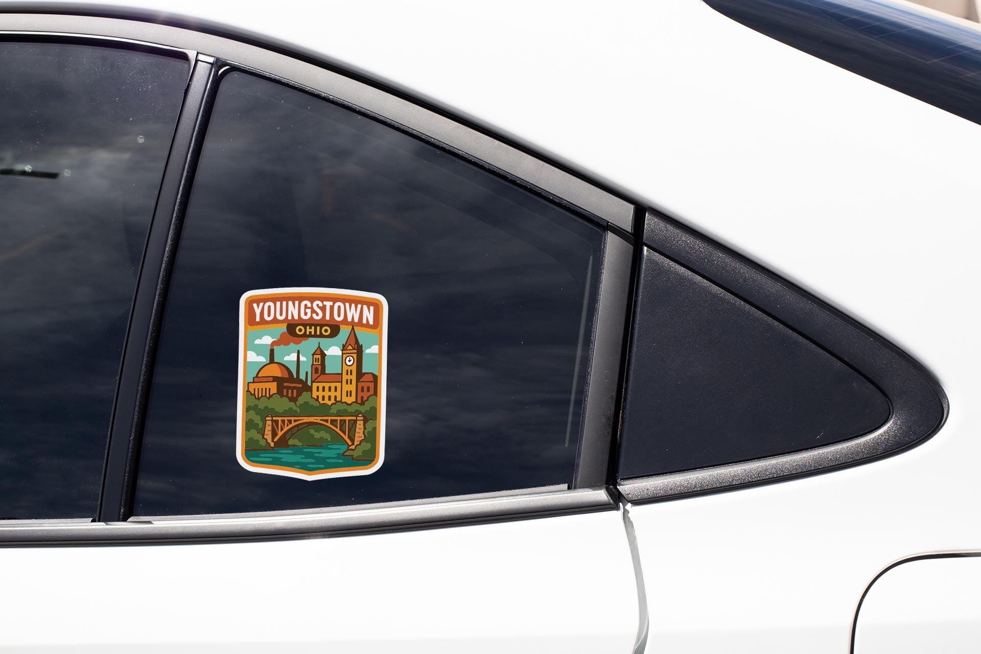 A sticker on the side of a car window, displaying a cityscape with a bridge and buildings.