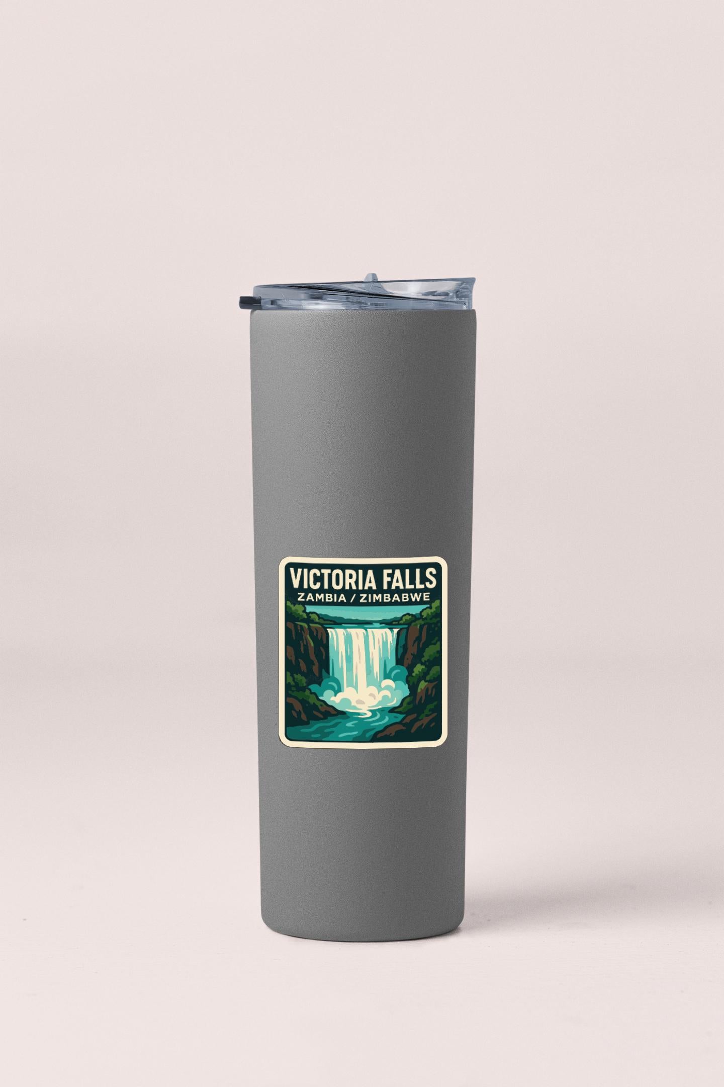 A gray insulated tumbler with a label that says "VICTORIA FALLS ZAMBIA / ZIMBABWE" printed on it.